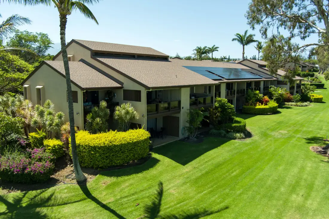 A low-rise building sits beside a broad, neatly landscaped lawn.