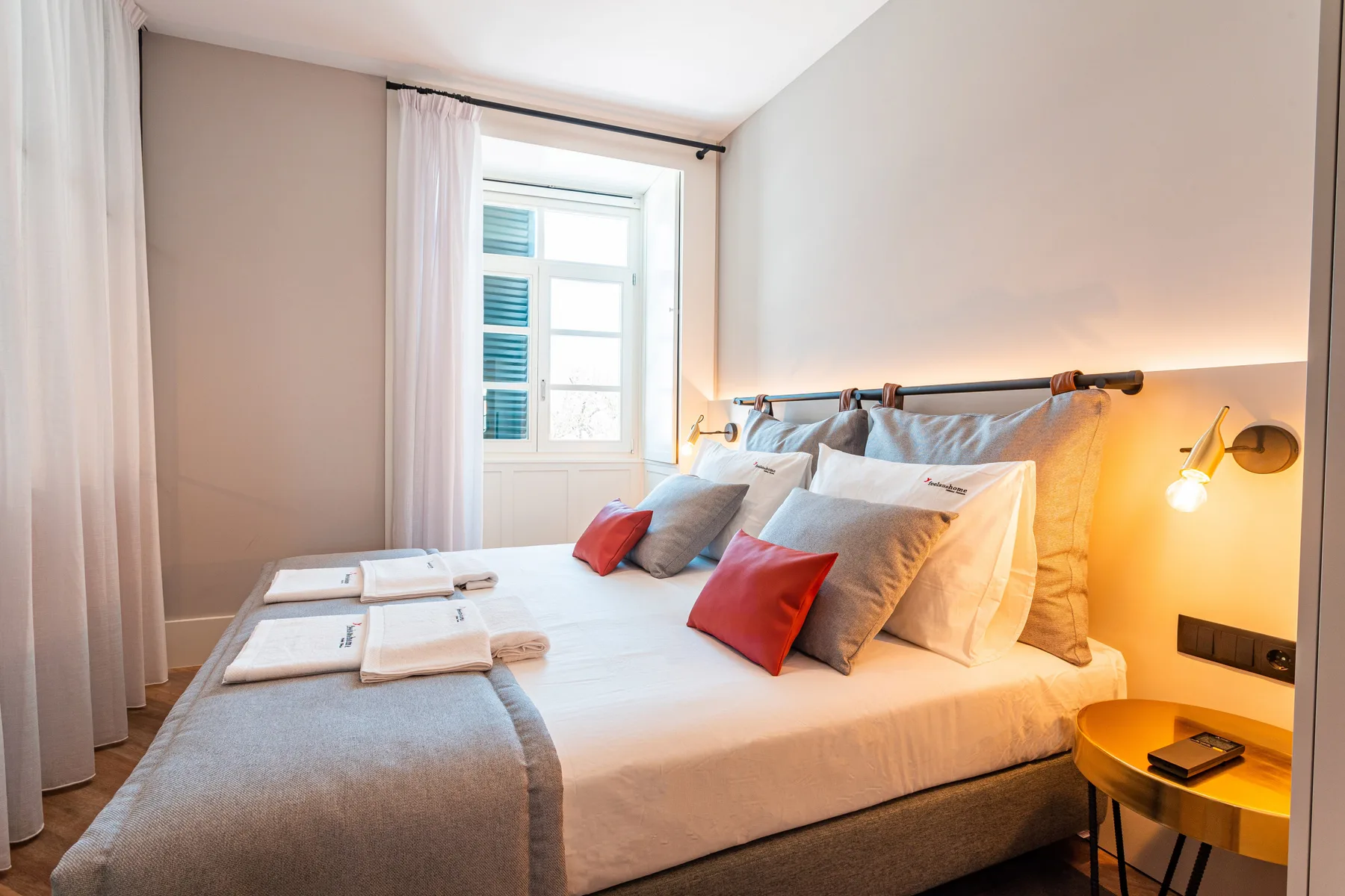 Un dormitorio con una cama, almohadas y una ventana junto a la cama.