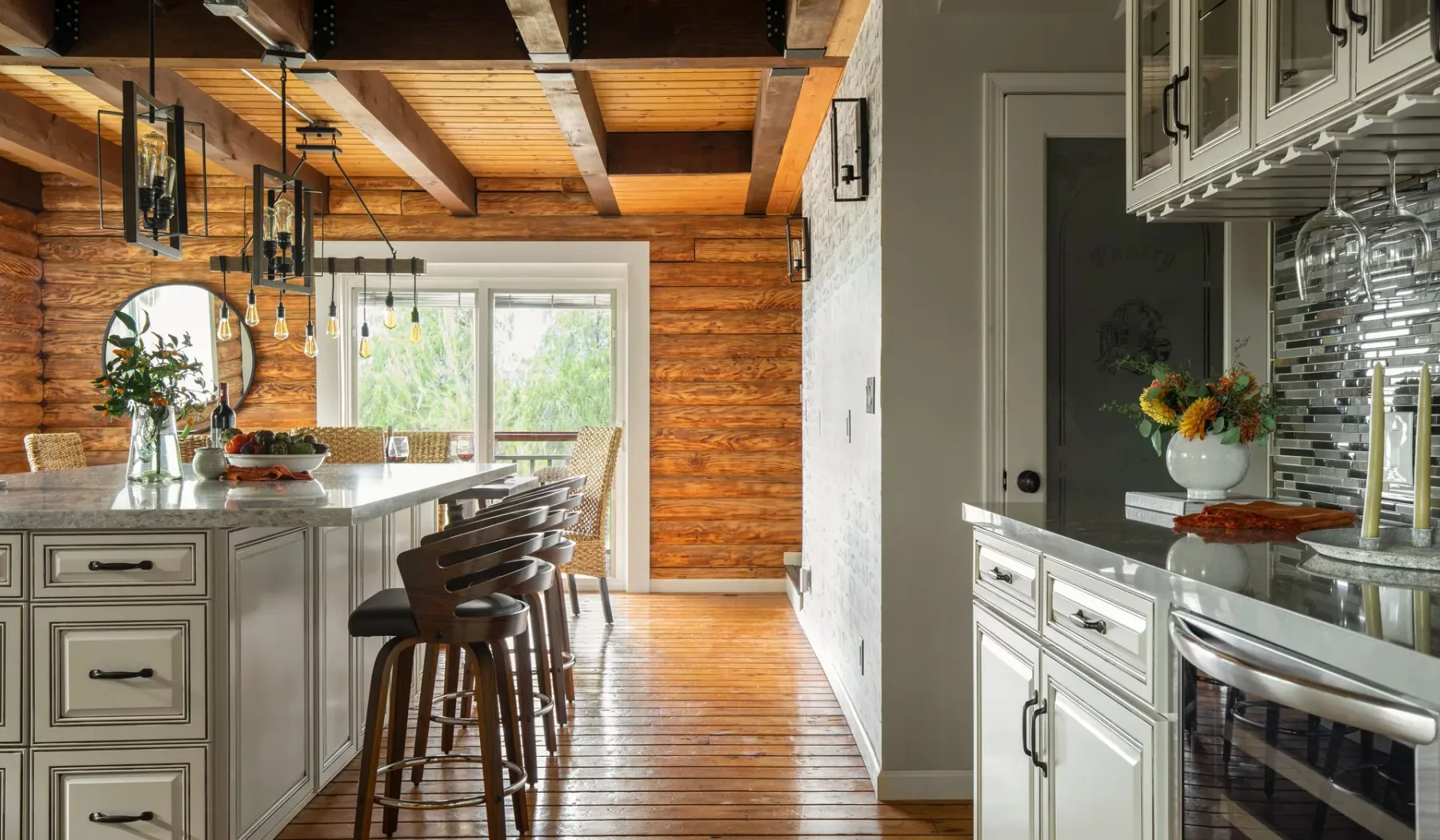 A rustic kitchen with a central island and wooden ceiling beams.