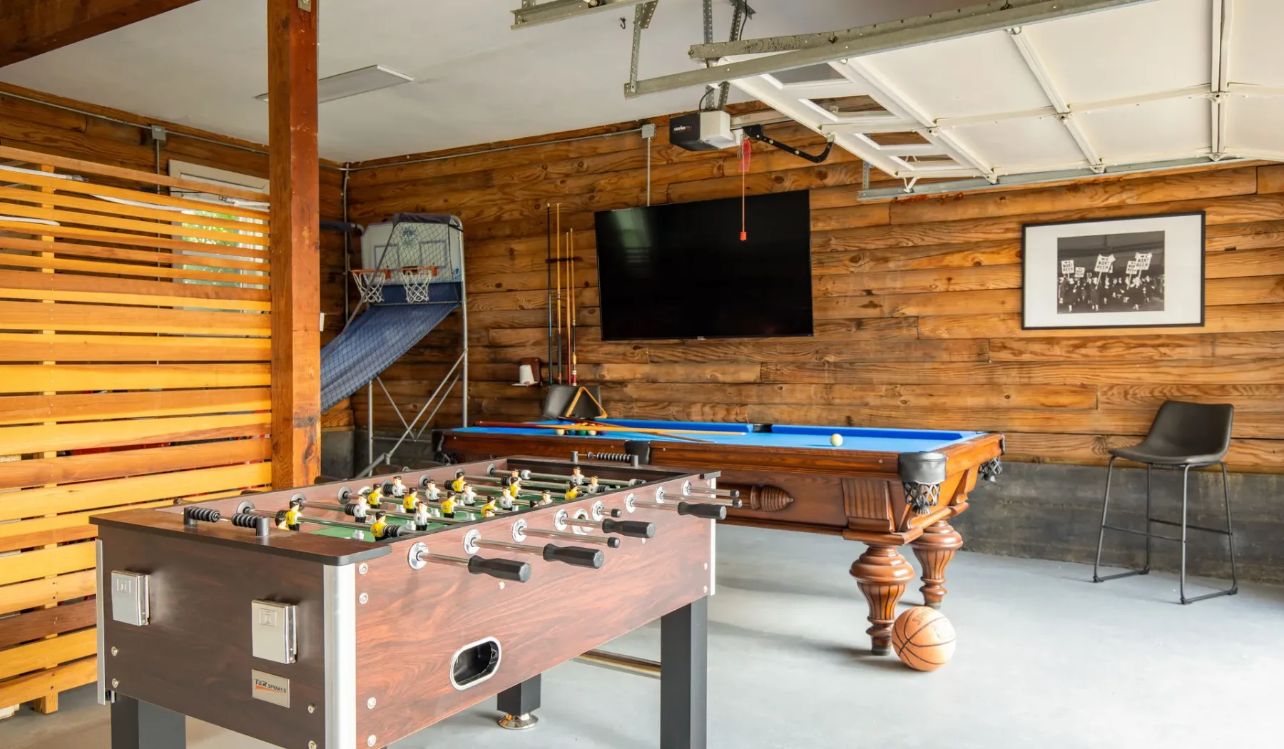 A recreation room with a foosball table and pool table.