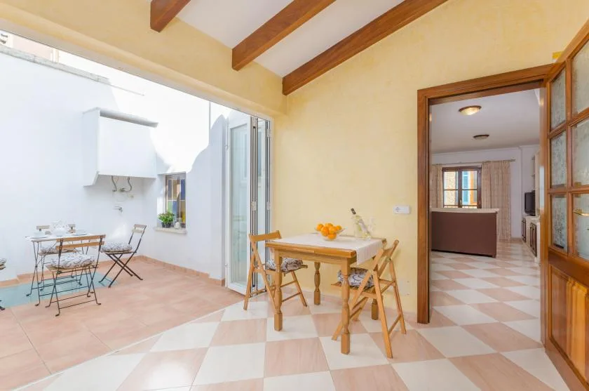 Un comedor luminoso con una mesa de madera se abre a una pequeña terraza.