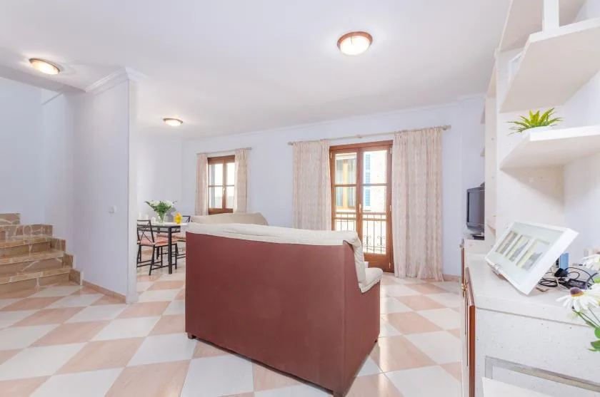 Una sala luminosa con asientos, una mesa de comedor y una puerta de vidrio.