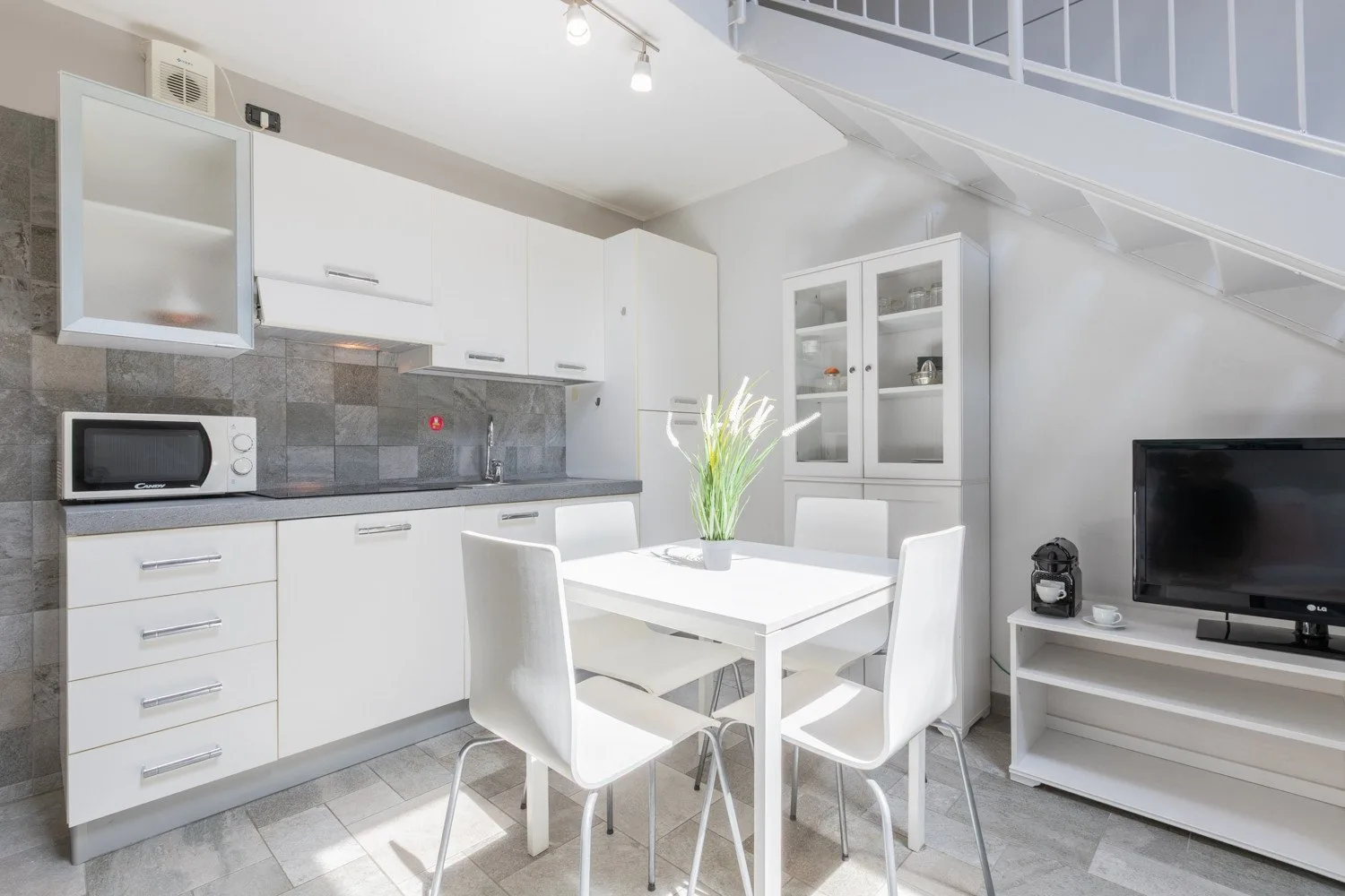 A bright kitchen and dining area with white cabinets and a table.