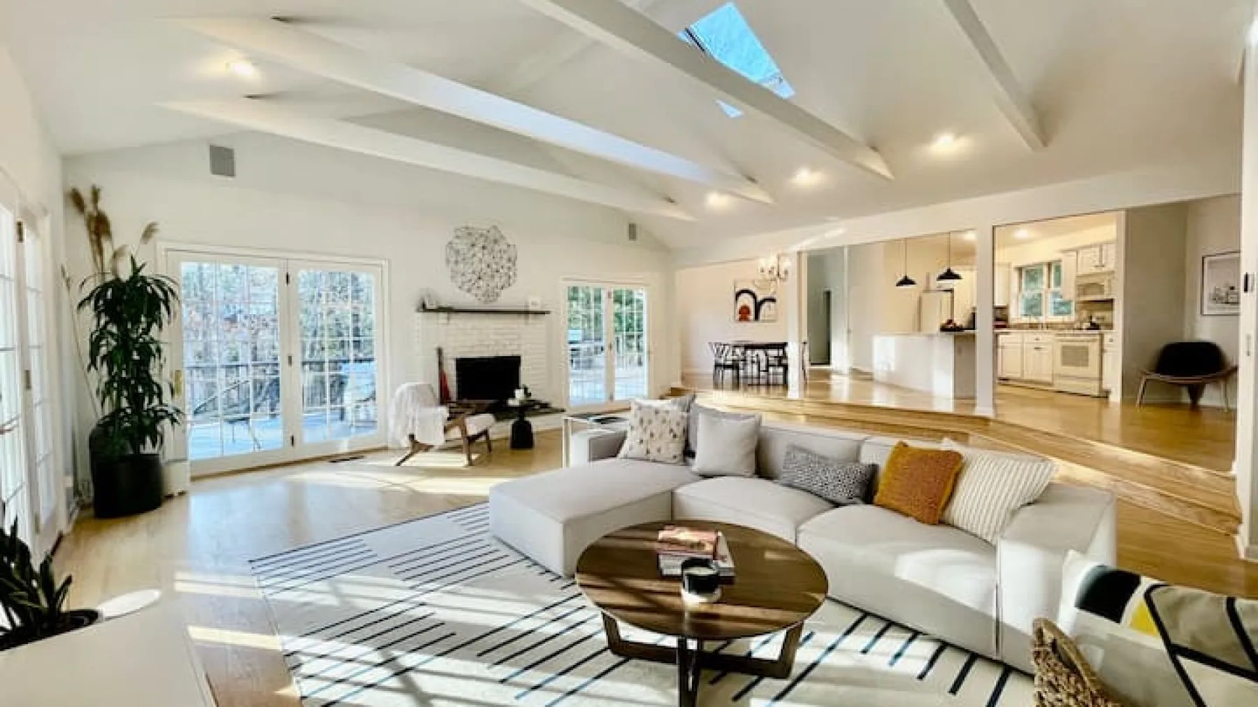 Open-plan living room with a sectional seating area and large windows.