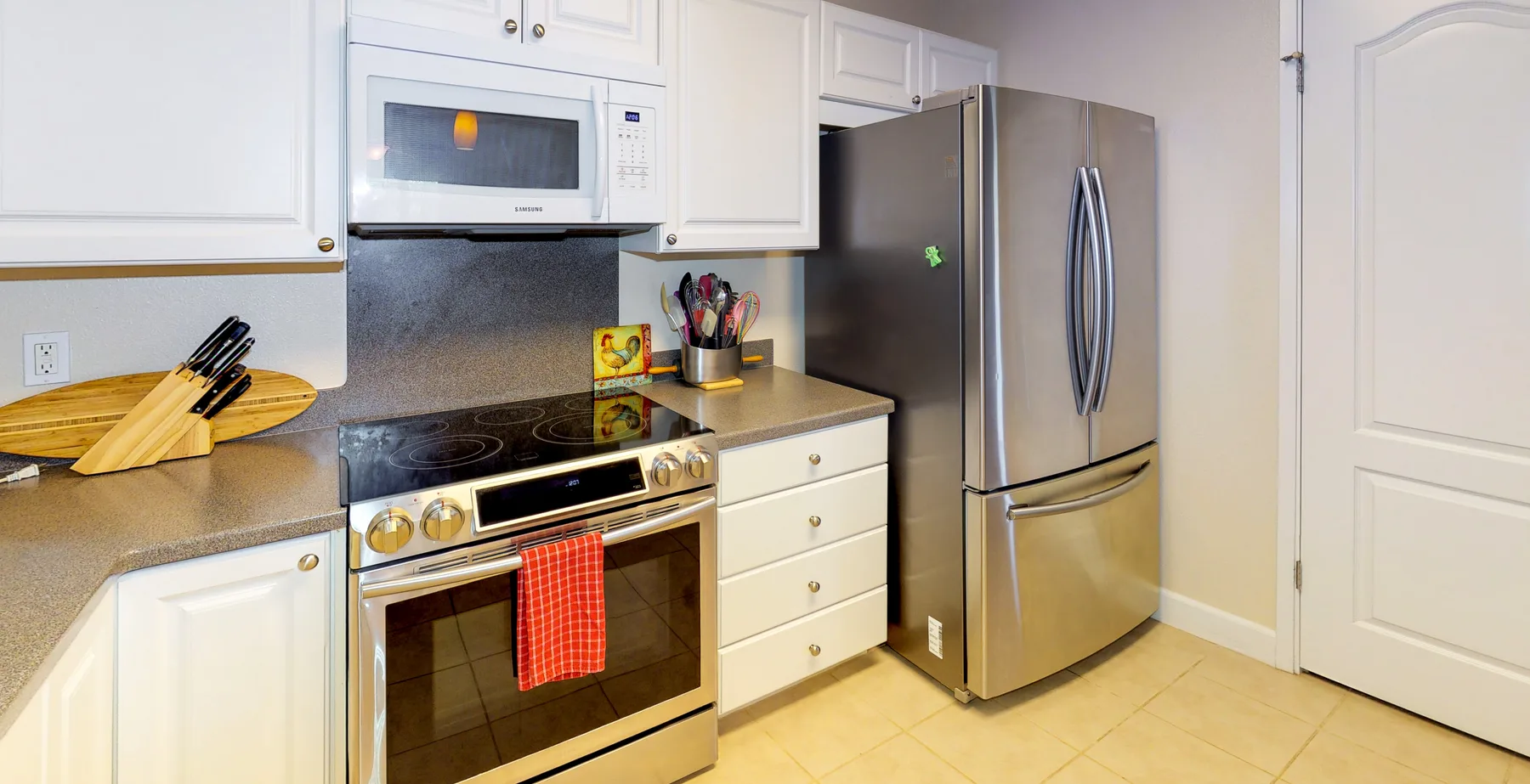 A bright kitchen with white cabinets and stainless steel appliances.