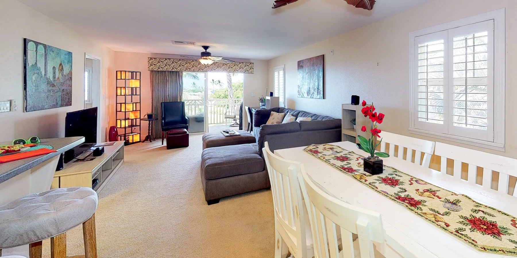 A bright living and dining room with a sectional sofa and a long dining table.