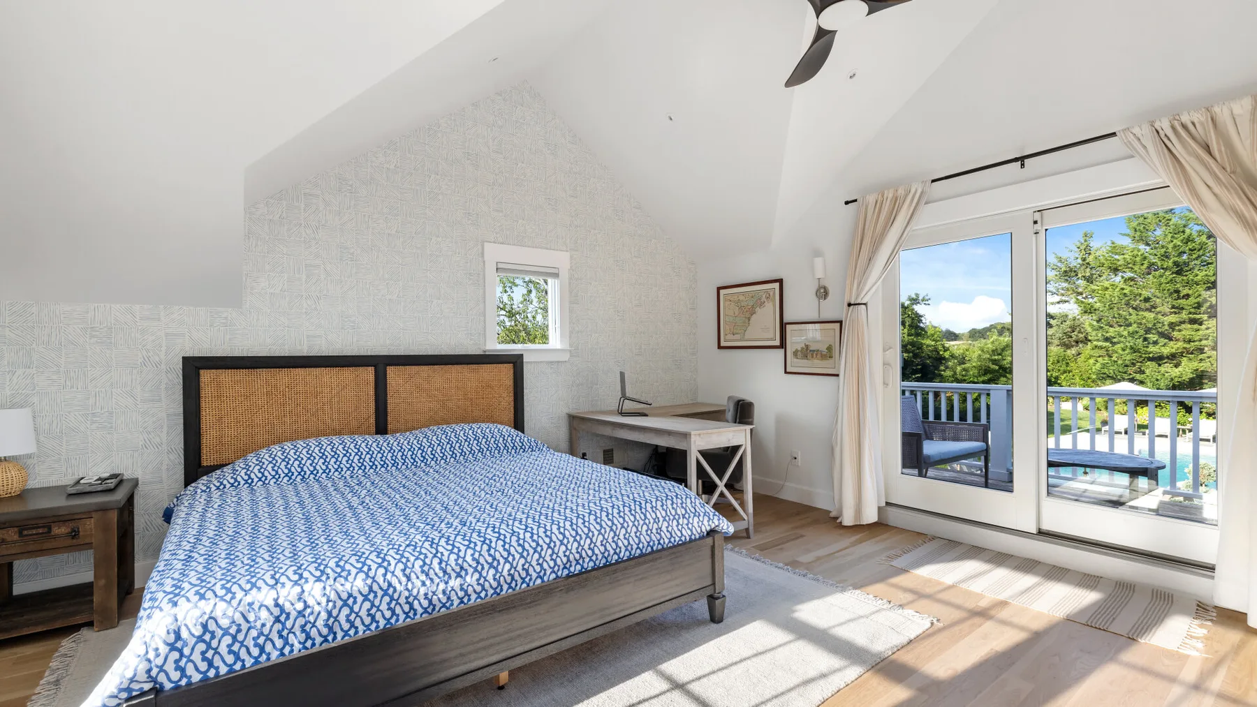 Un dormitorio con una cama junto a puertas de vidrio que dan a un balcón.
