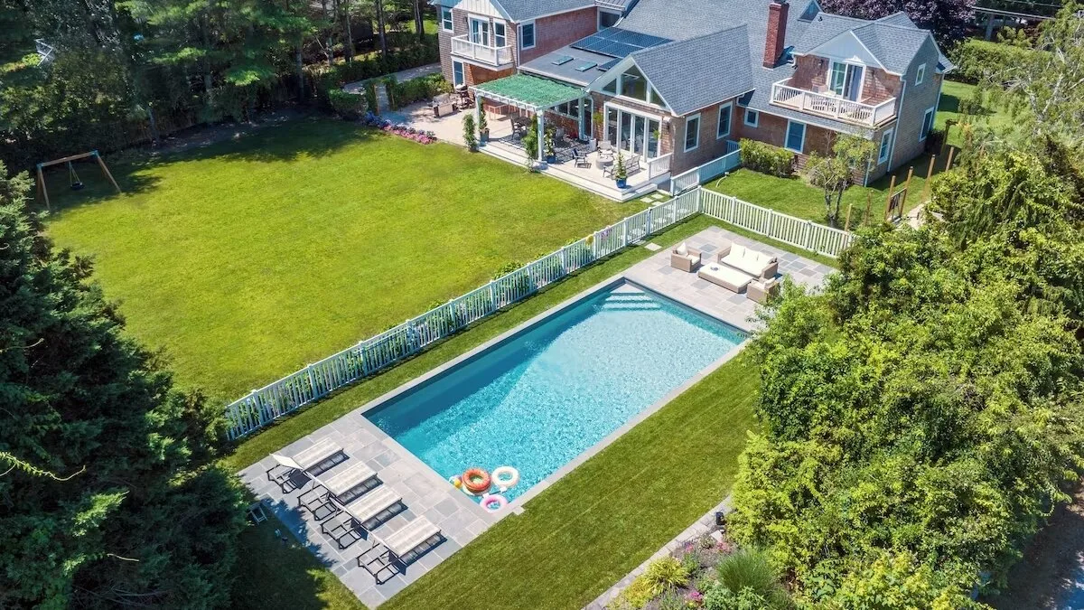 Aerial view of a house, swimming pool, and lawn.