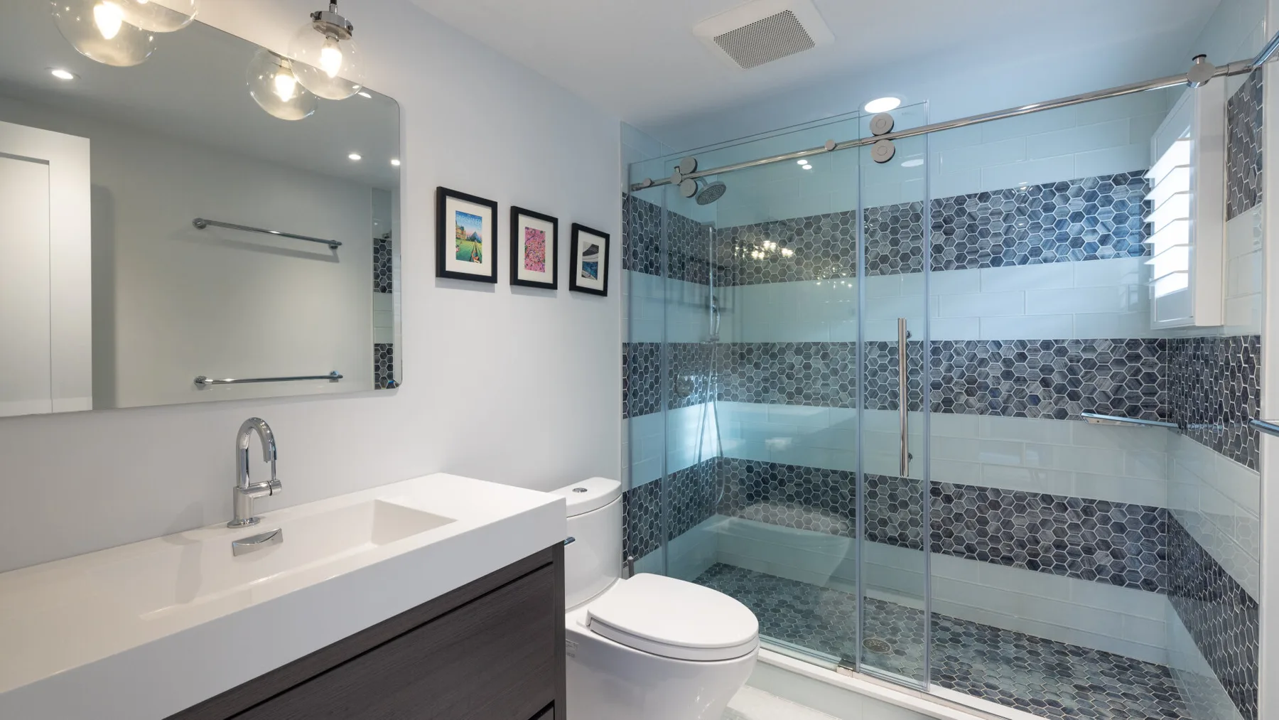 Un baño con lavabo, inodoro y ducha de vidrio.