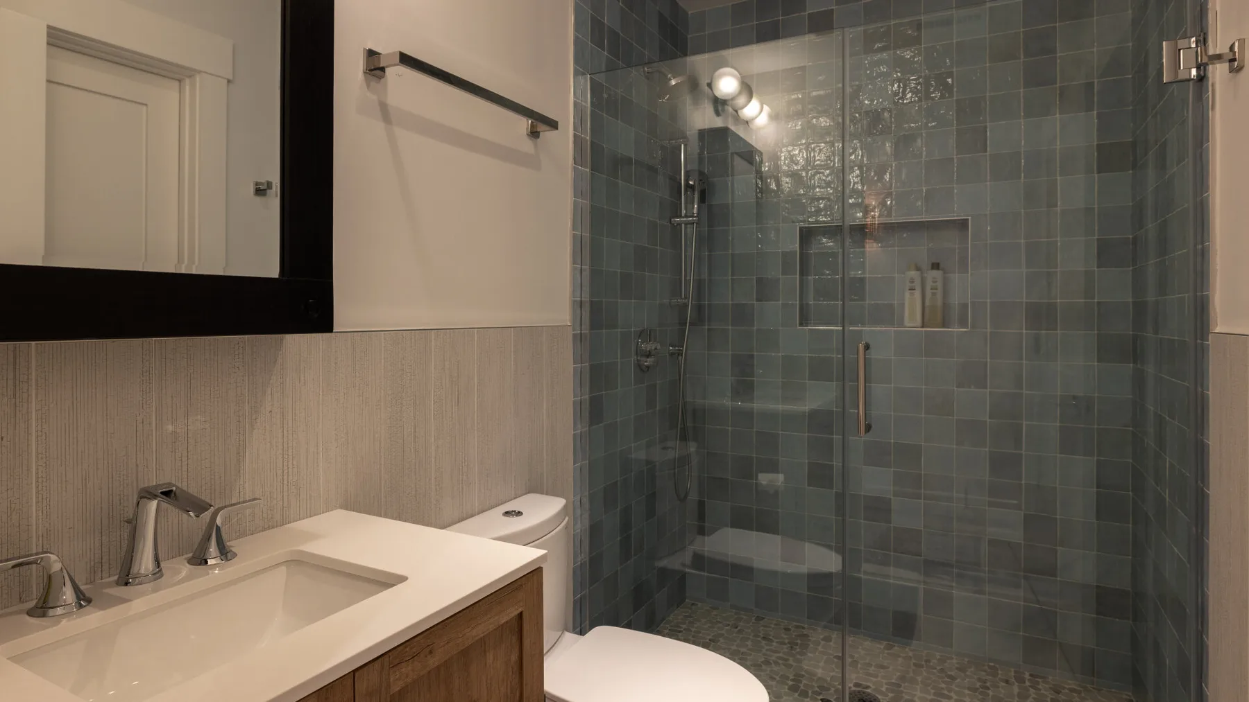 Un baño con lavabo y una ducha de vidrio.