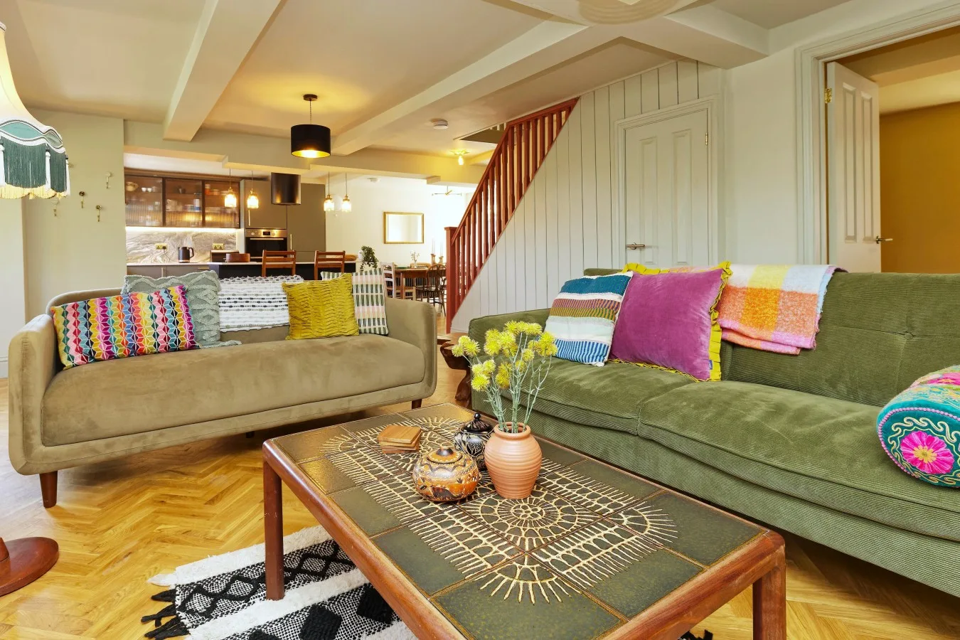 A living room with seating, colorful cushions, and a coffee table.