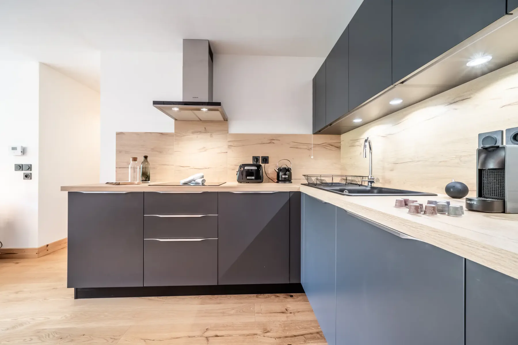 Modern kitchen with dark cabinets, a countertop, and cooking appliances.