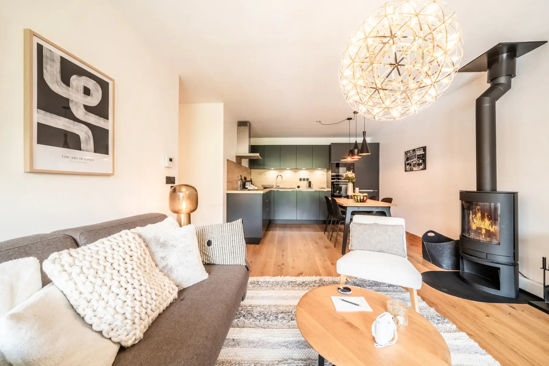 A living room with seating, a coffee table, and a wood-burning stove.