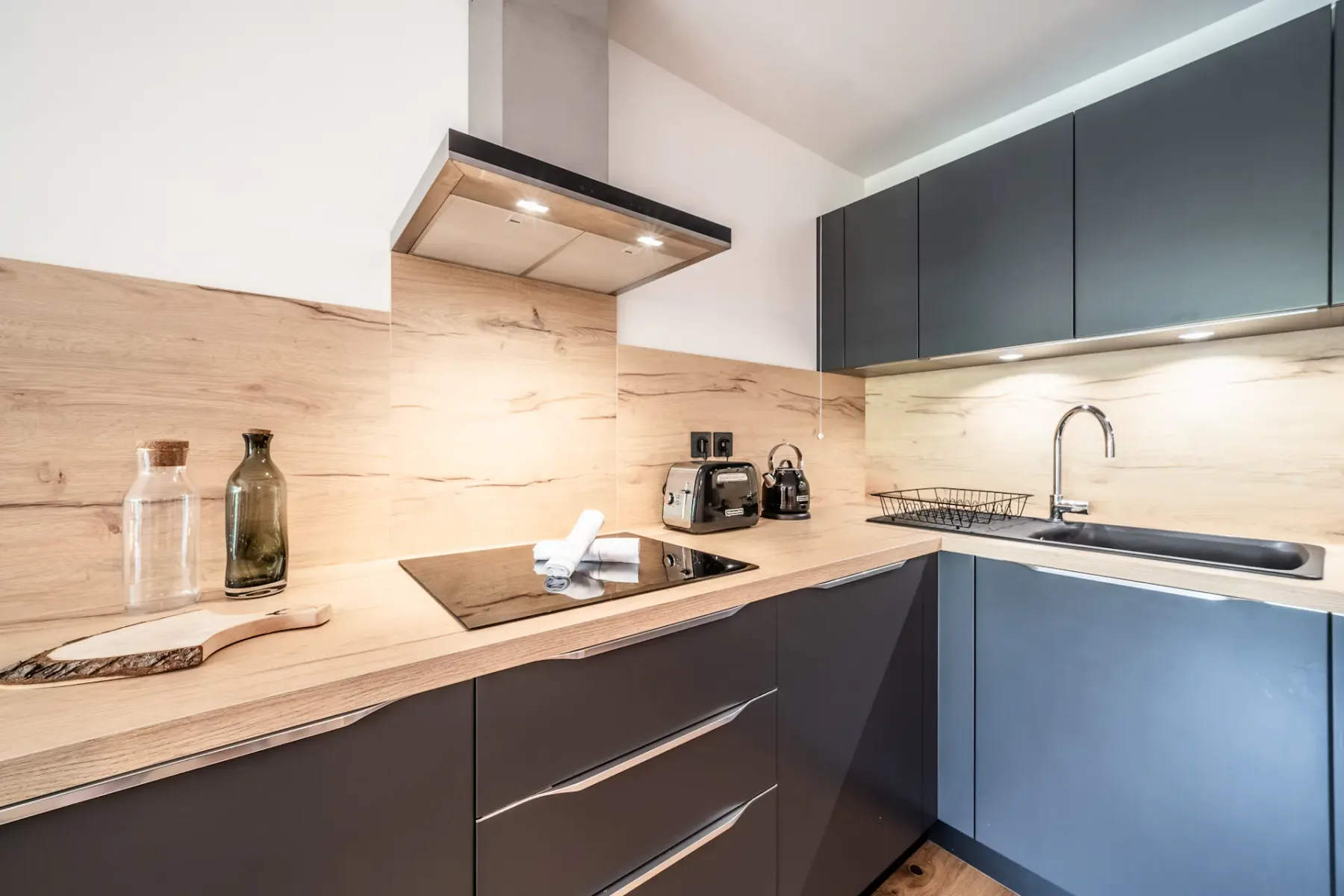 Modern kitchen with dark cabinets, a countertop, and a sink.