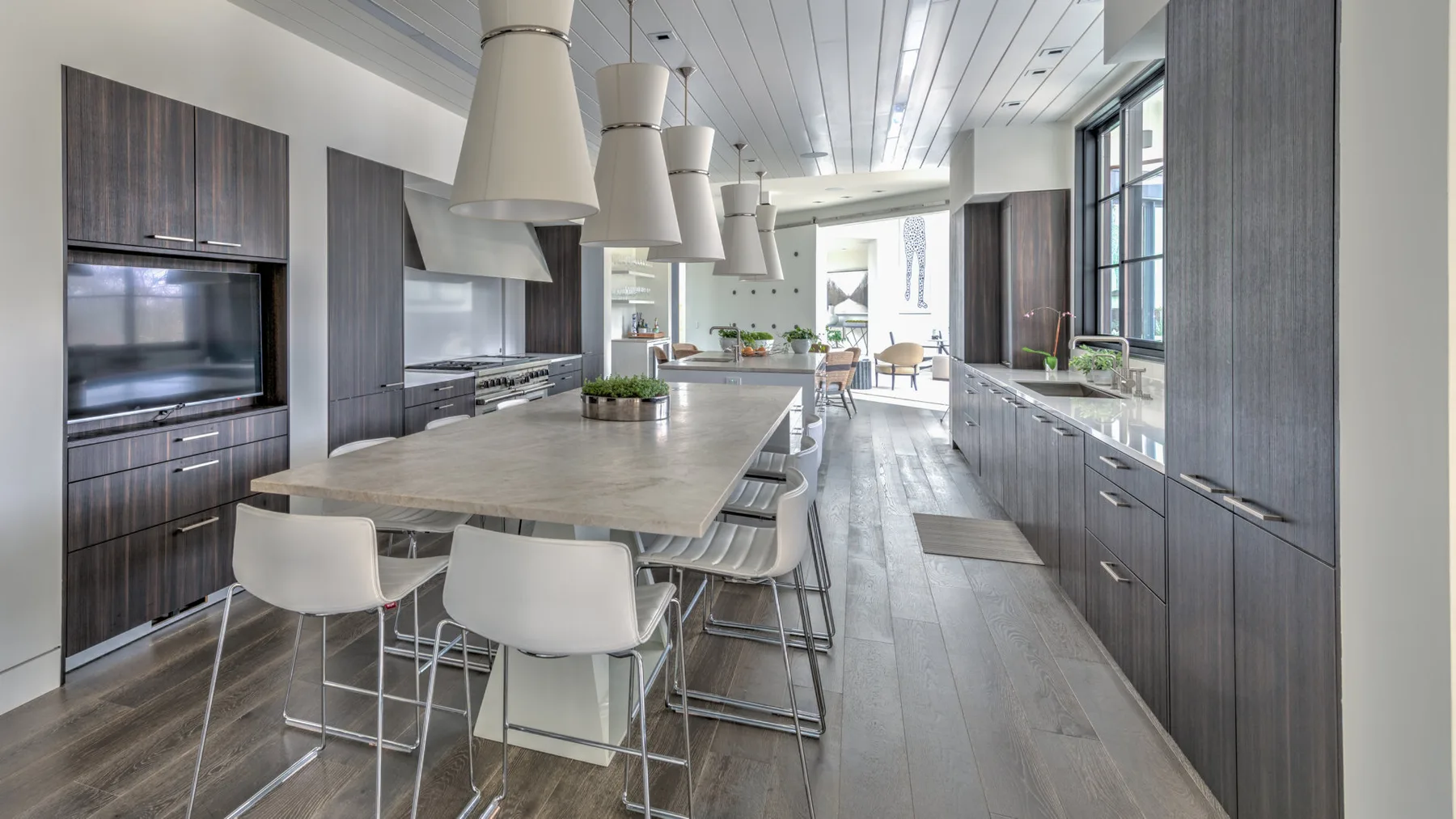 A modern kitchen with a long island and dining seating.