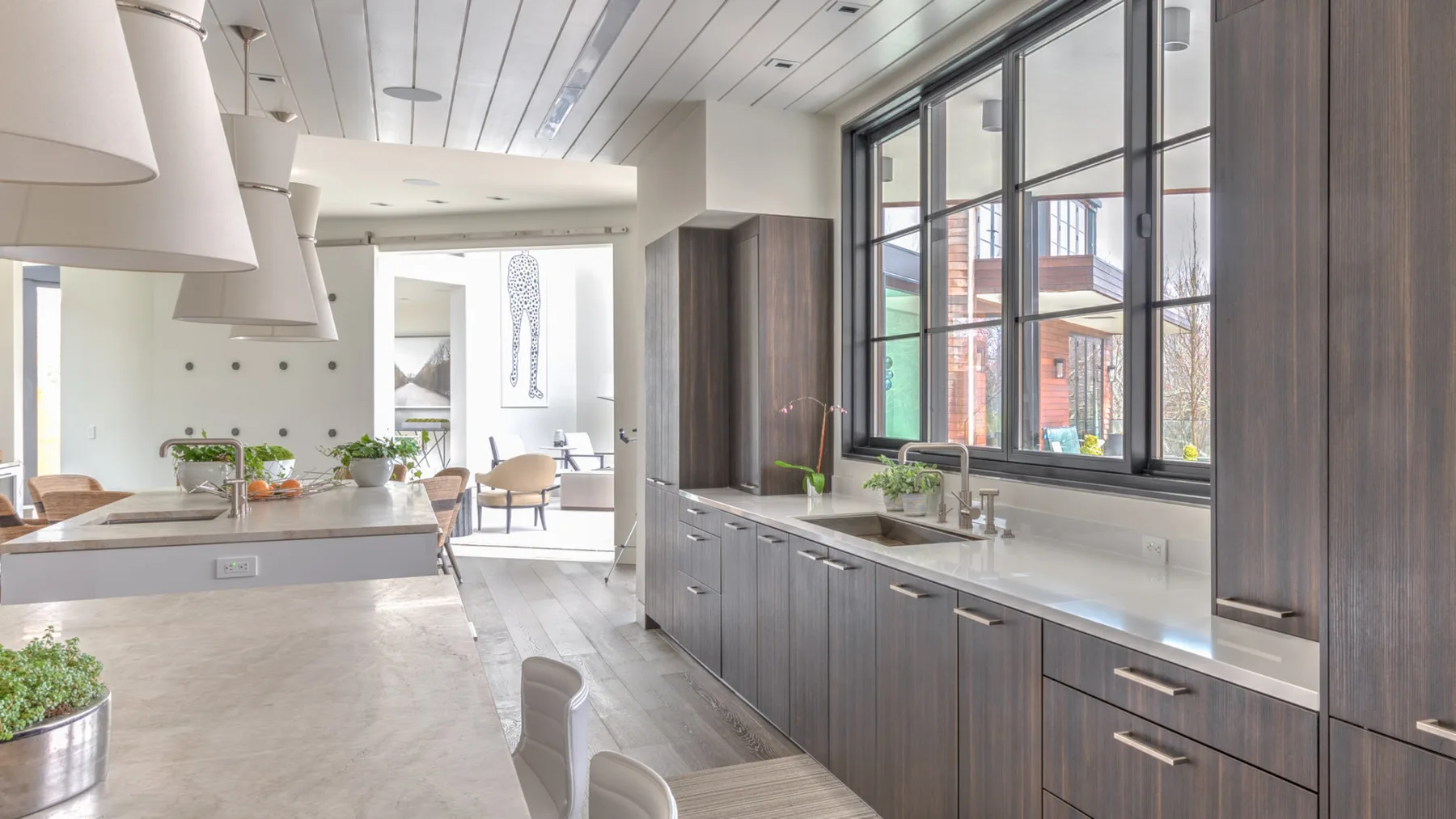 A bright kitchen with dark cabinetry and large windows.