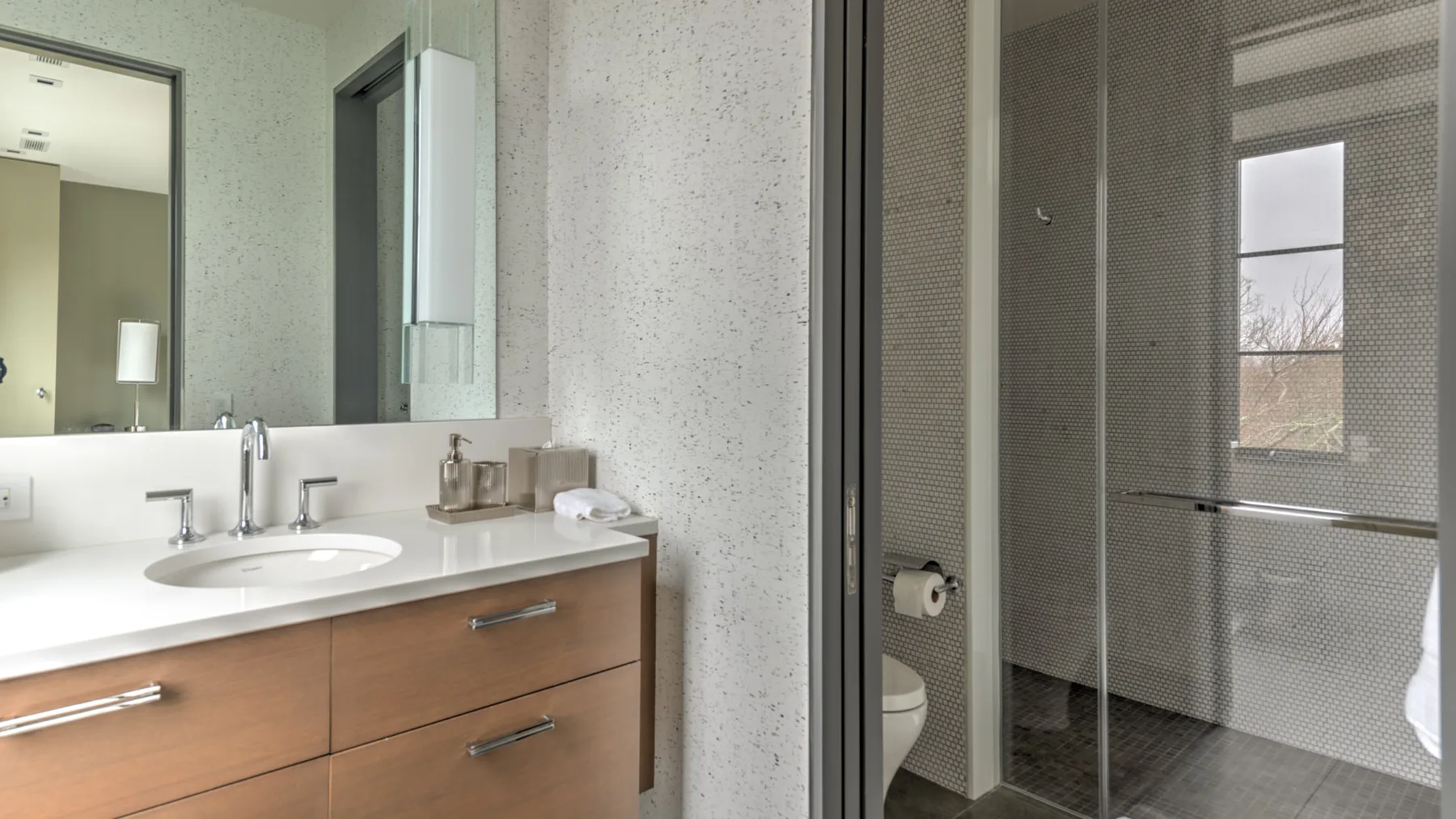 A bathroom with a vanity and a glass shower enclosure.