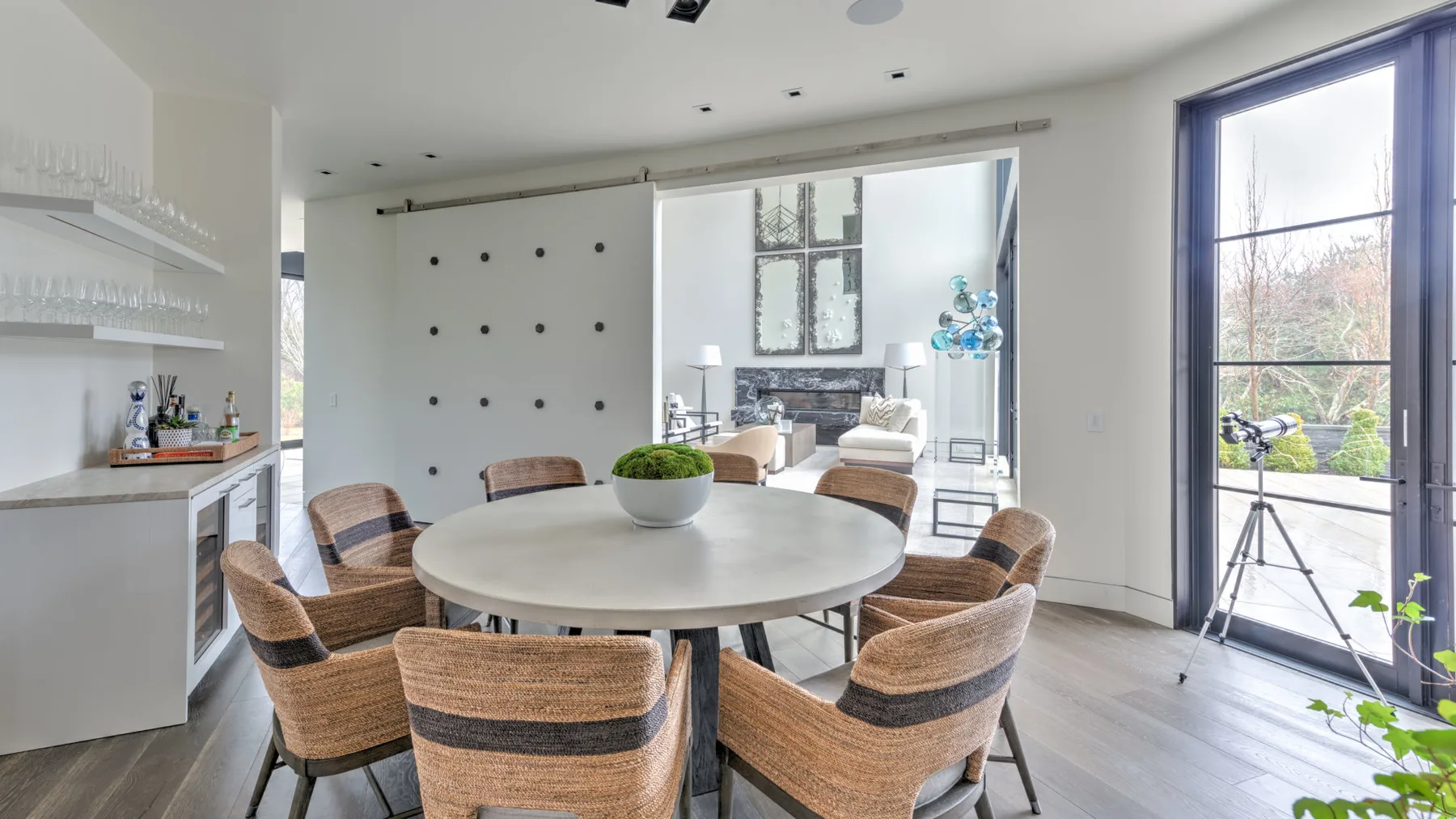 A bright dining area with a round table and woven seating.