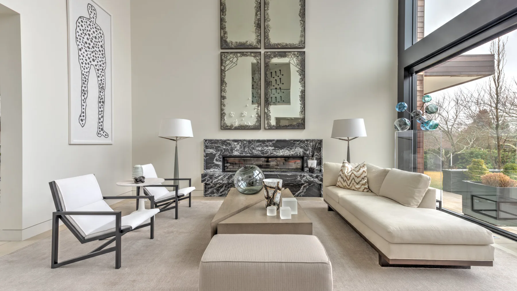 A bright living room with a fireplace, seating, and large windows.