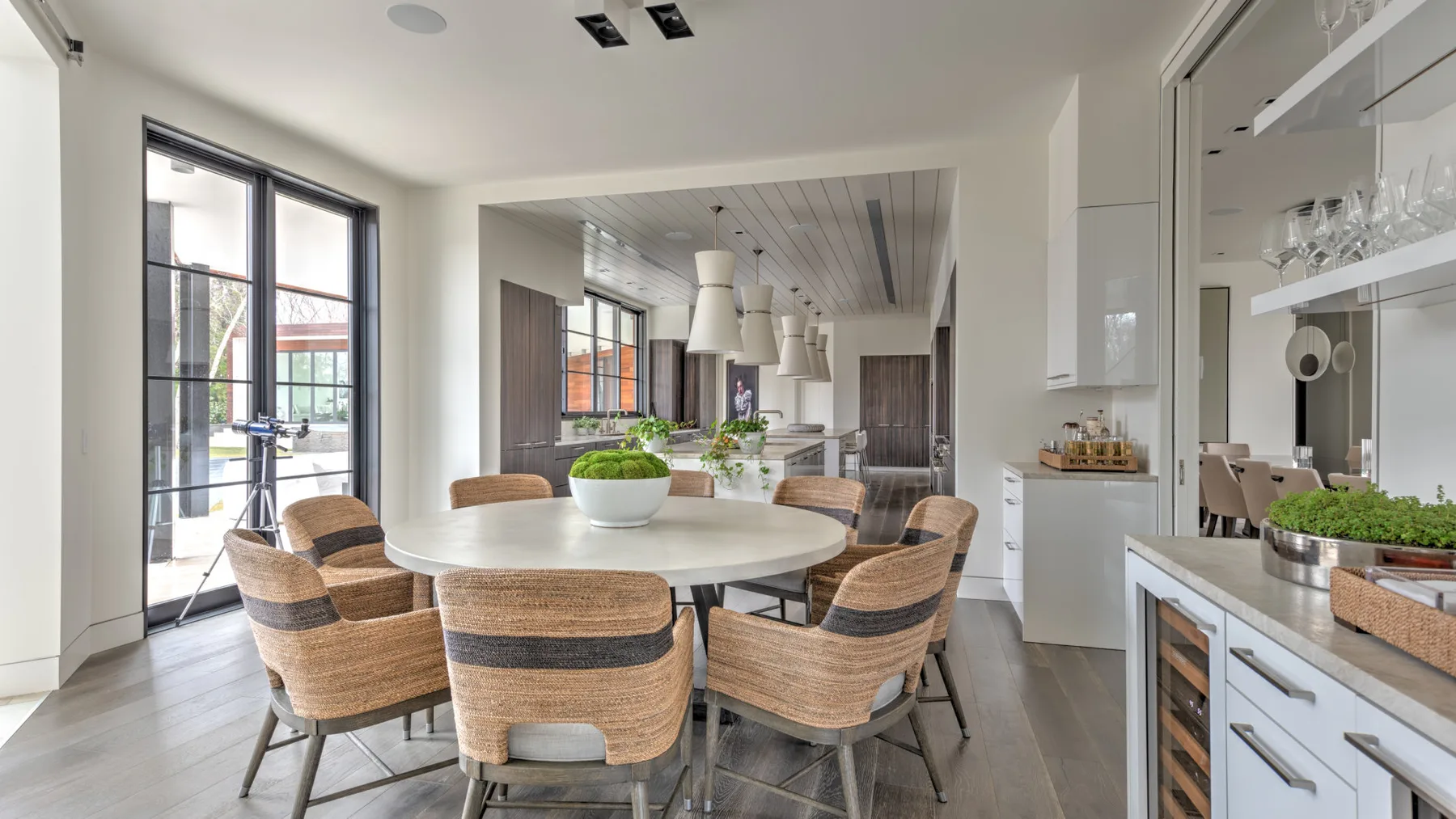 A bright dining area with a round table and woven seating.