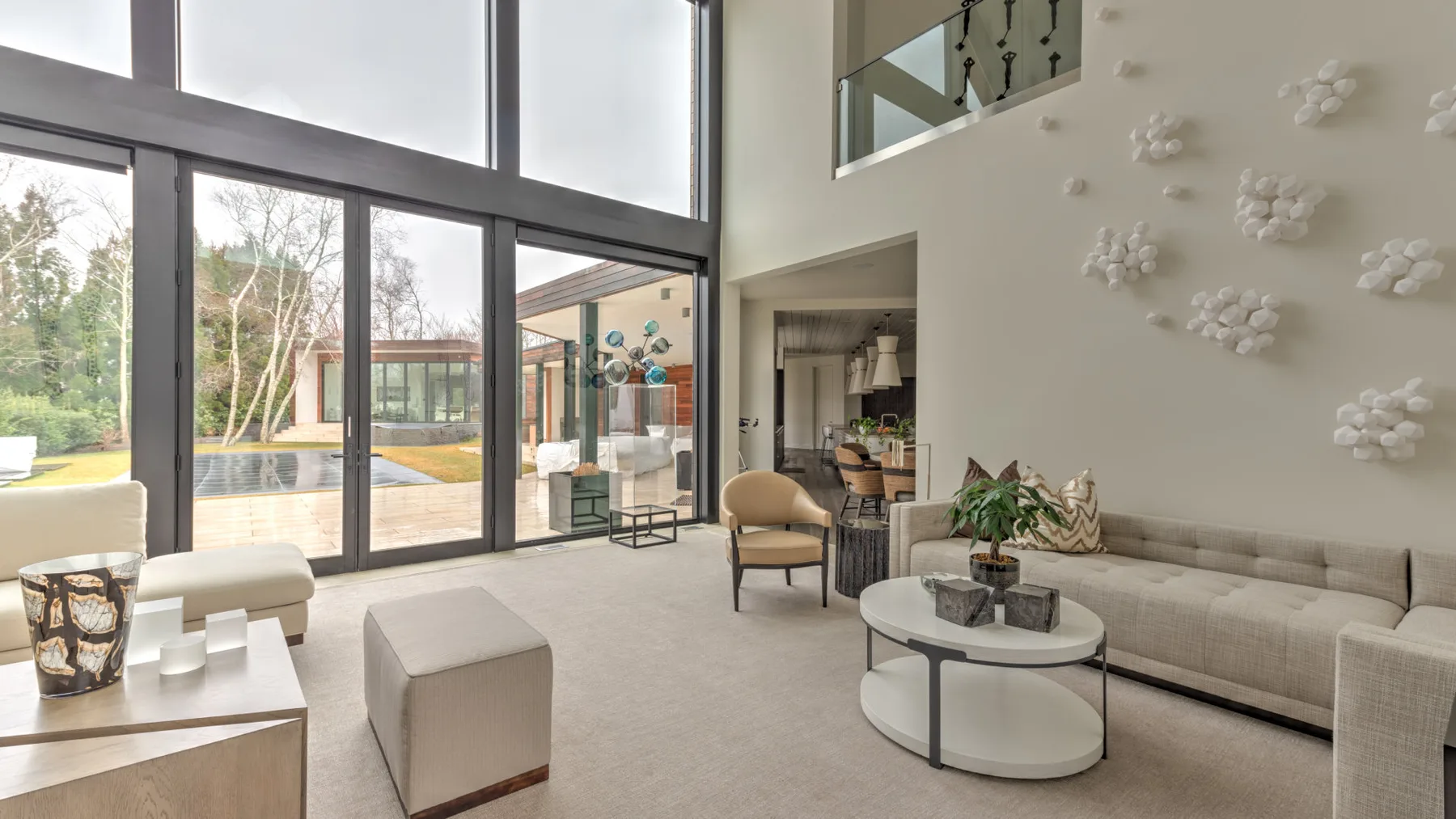 A bright living room with floor-to-ceiling windows and a seating area.
