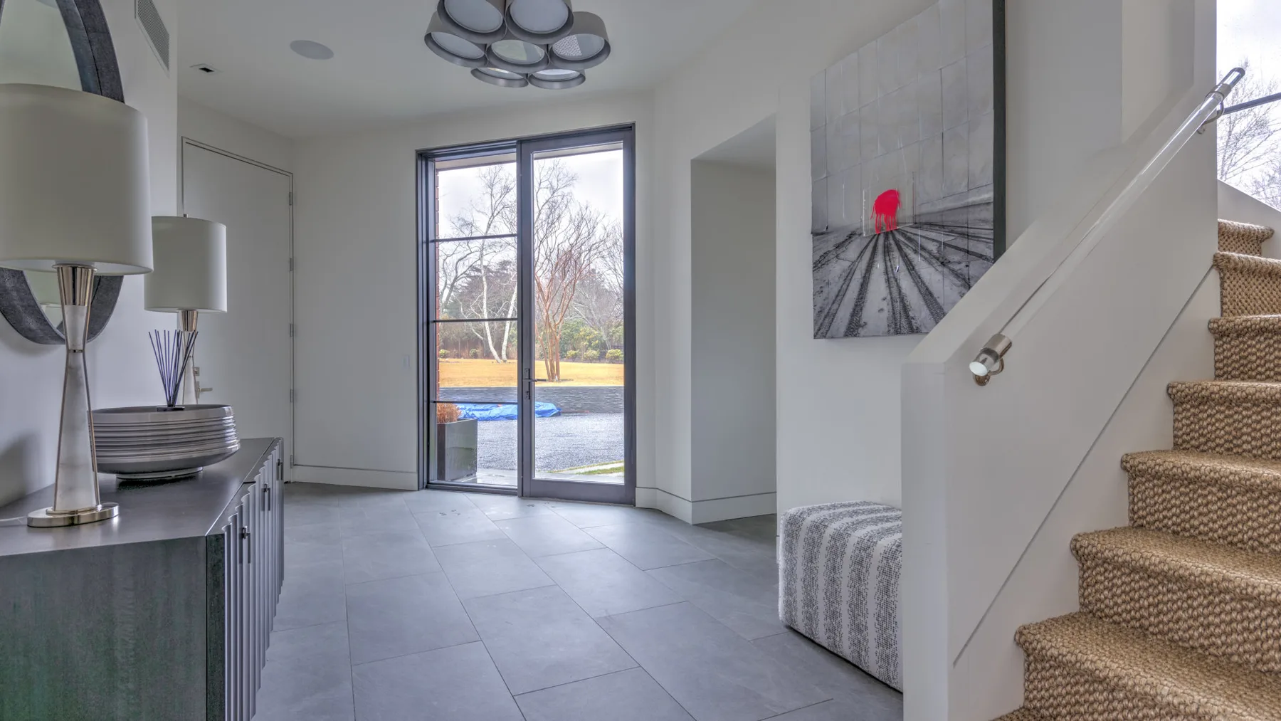 A bright entry hall with a glass door opening onto an outdoor patio.