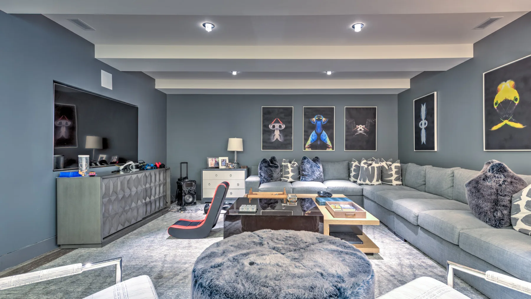 A living room with a sectional seating area and framed artwork on the walls.