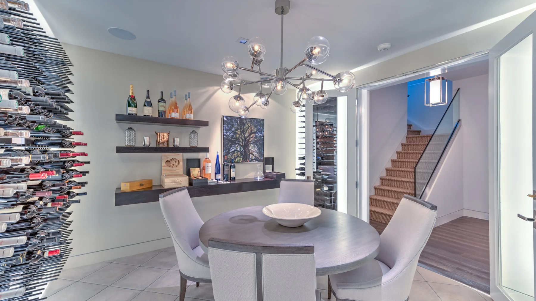 A modern dining area with a round table beside a staircase.