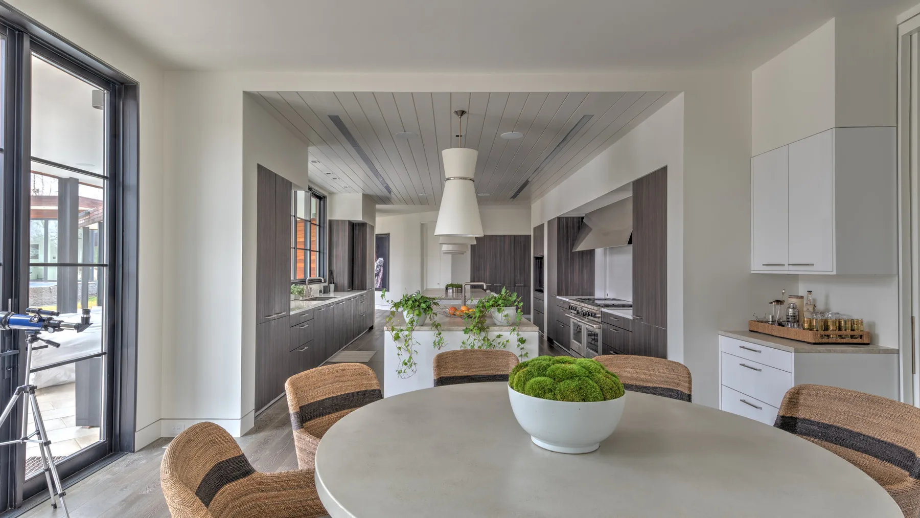 A modern kitchen and dining area with a round table and central island.