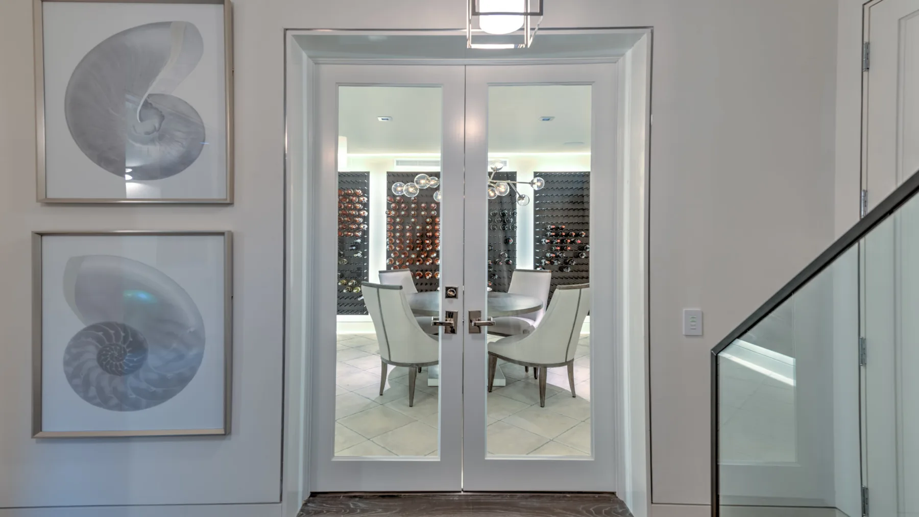 A dining area is visible through glass double doors, with seating around a table.