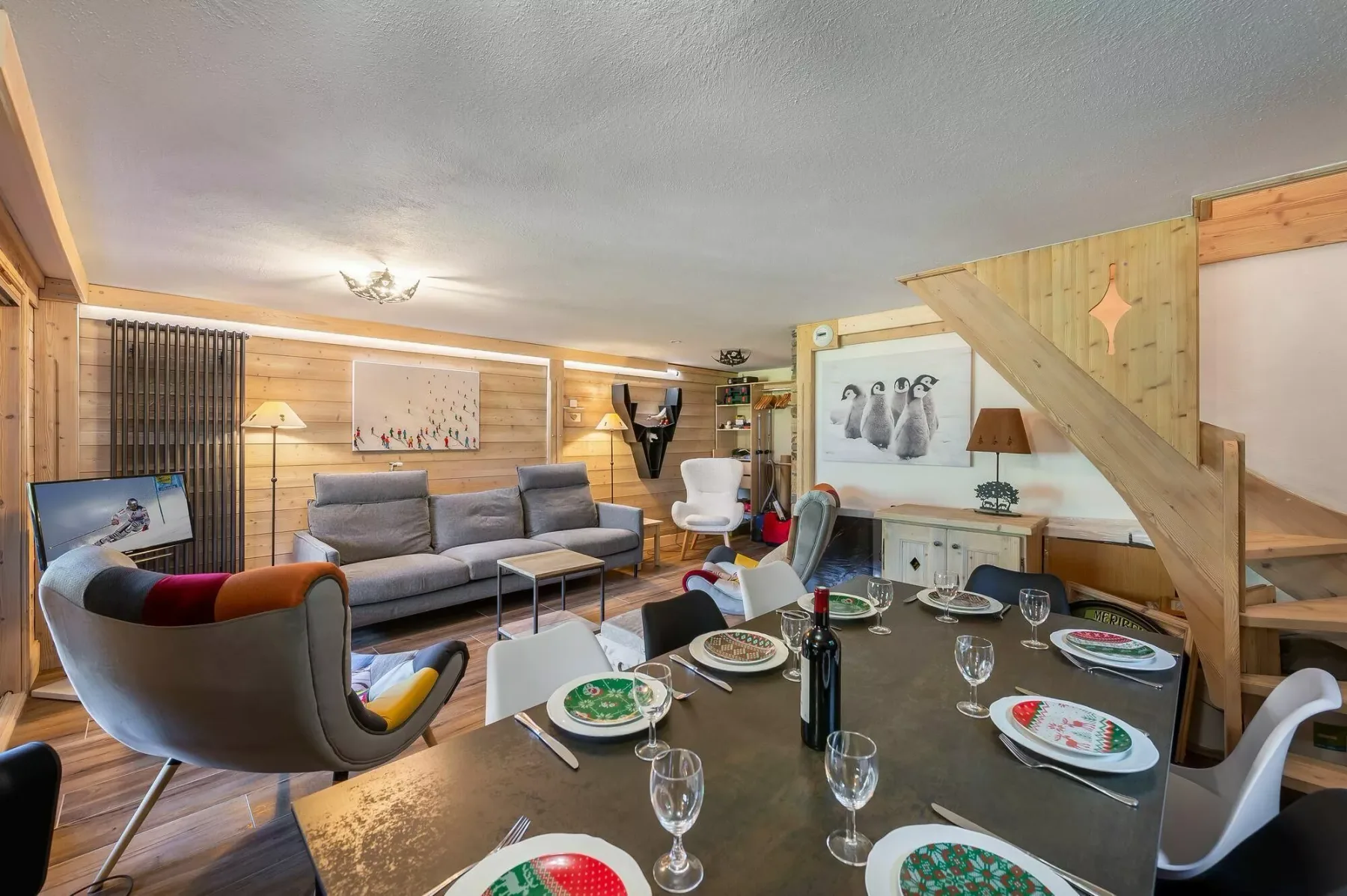 A wood-paneled living and dining area with a sofa and a set dining table.