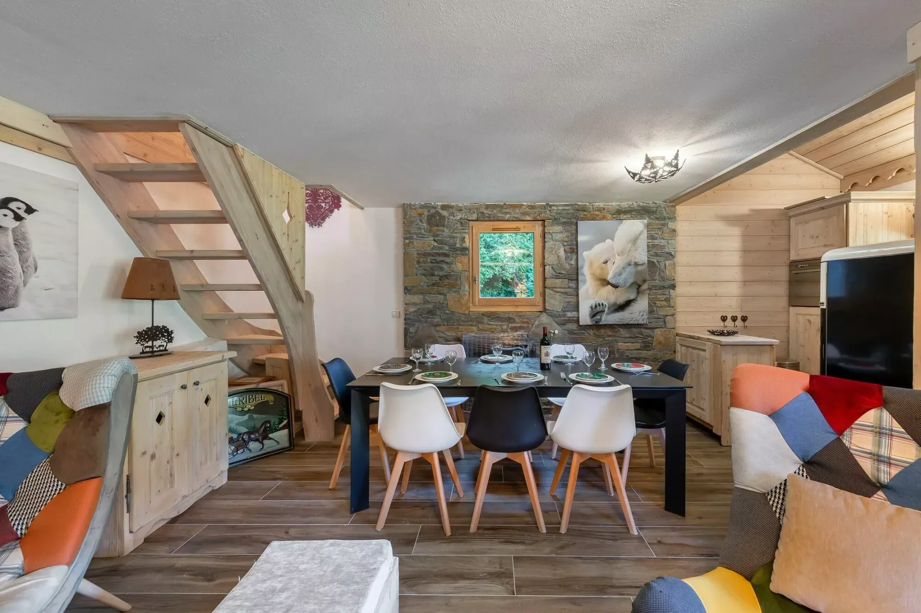 A dining area with a set table, wooden seating, and a stone accent wall.