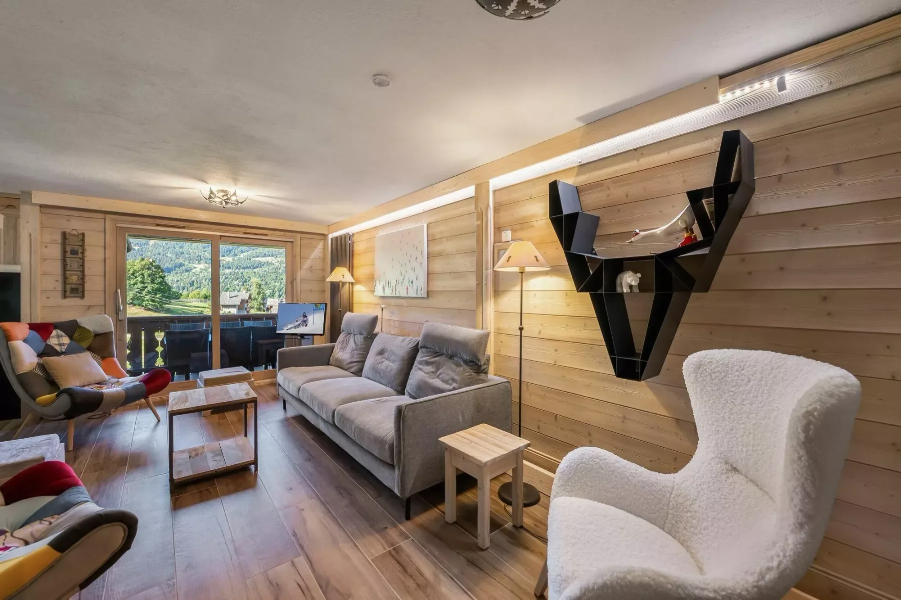 A wood-paneled living room with gray seating and a large wall-mounted shelf.