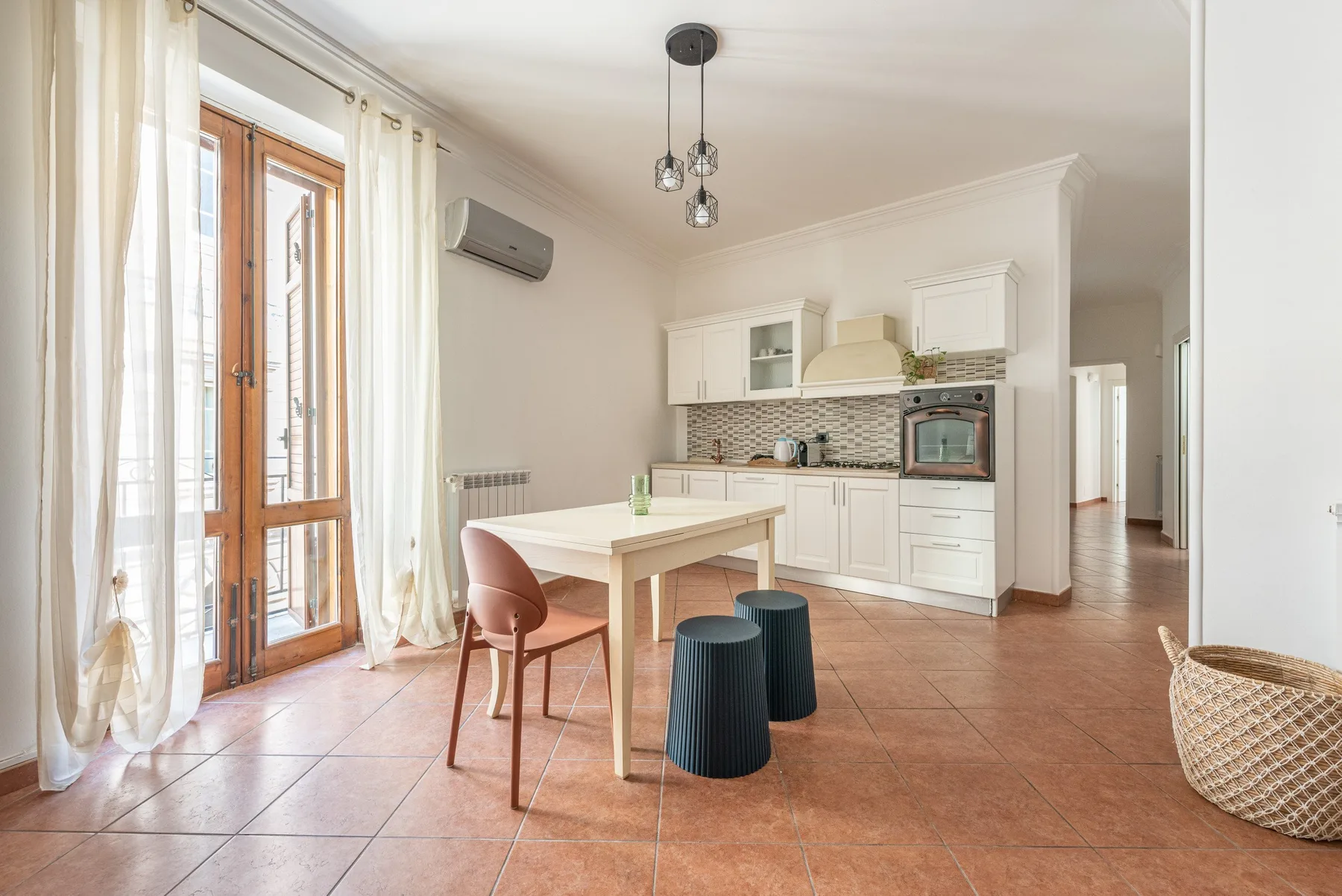 A bright kitchen and dining area with white cabinets and a table.