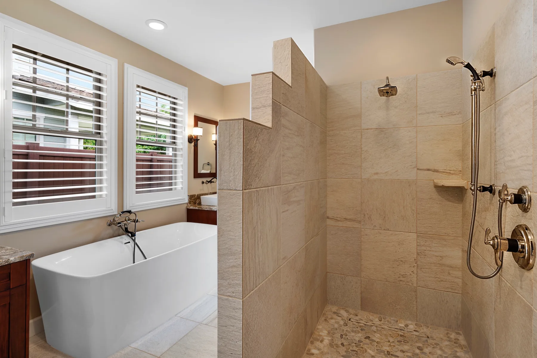 Un baño con una bañera junto a una ducha con paredes de azulejos.
