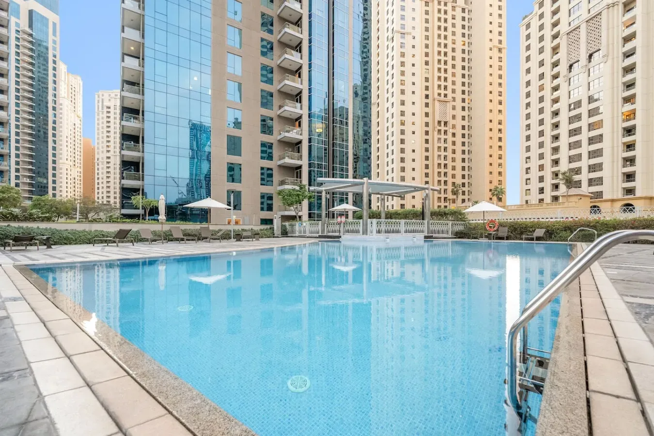 Una piscina al aire libre está rodeada de edificios altos.