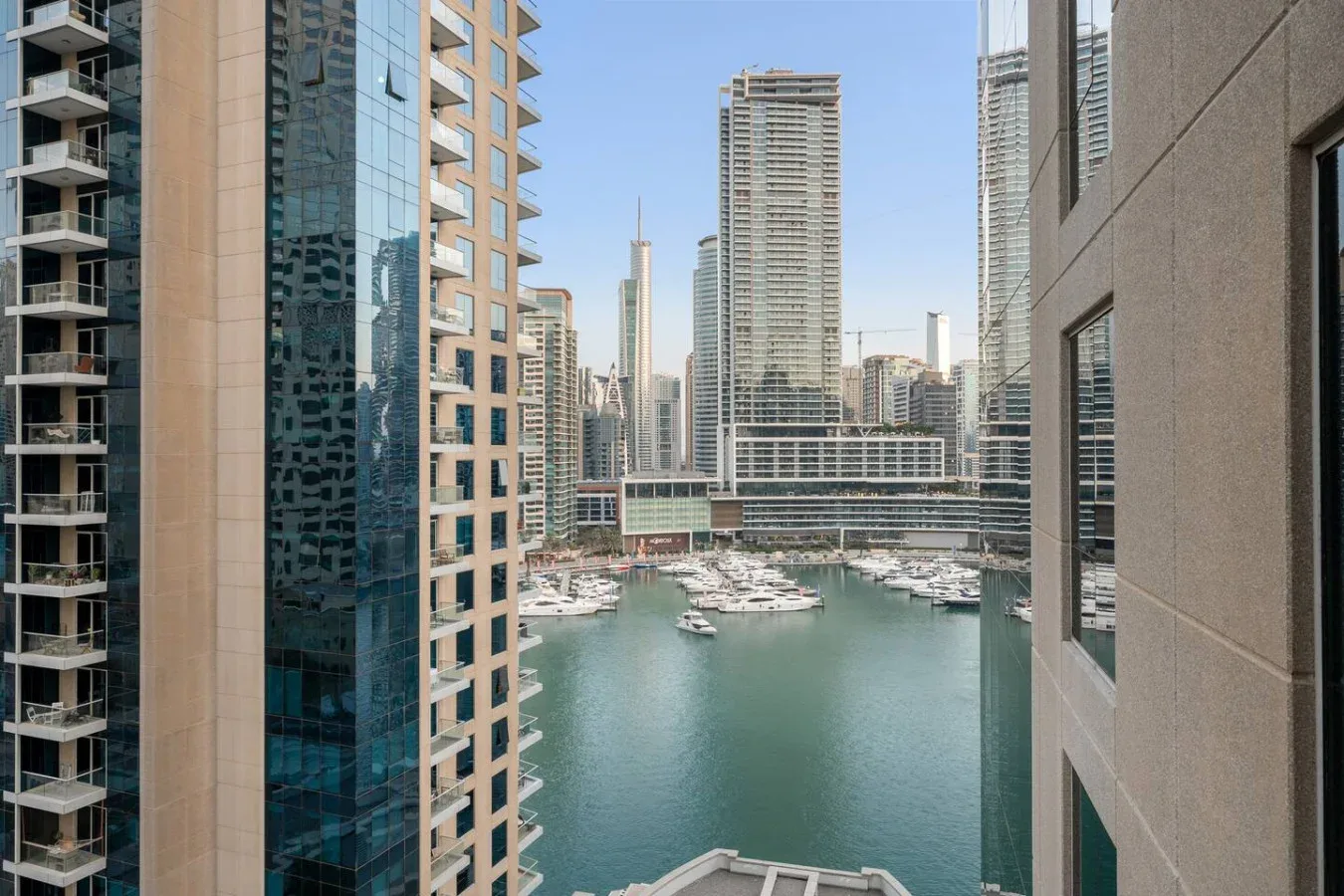 A marina and surrounding high-rise buildings are visible from between two nearby towers.