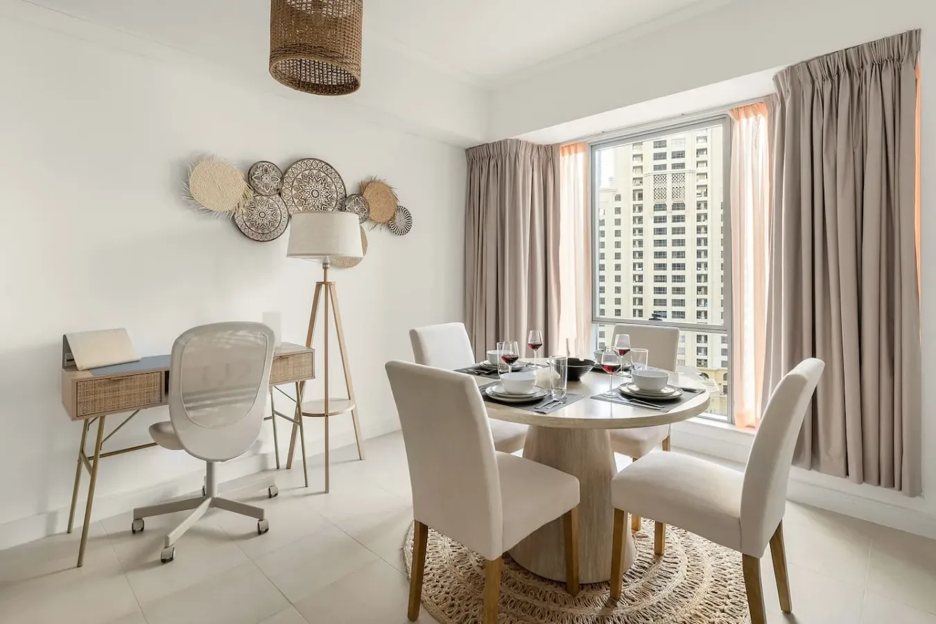 Comedor con una mesa redonda y una amplia ventana con cortinas.
