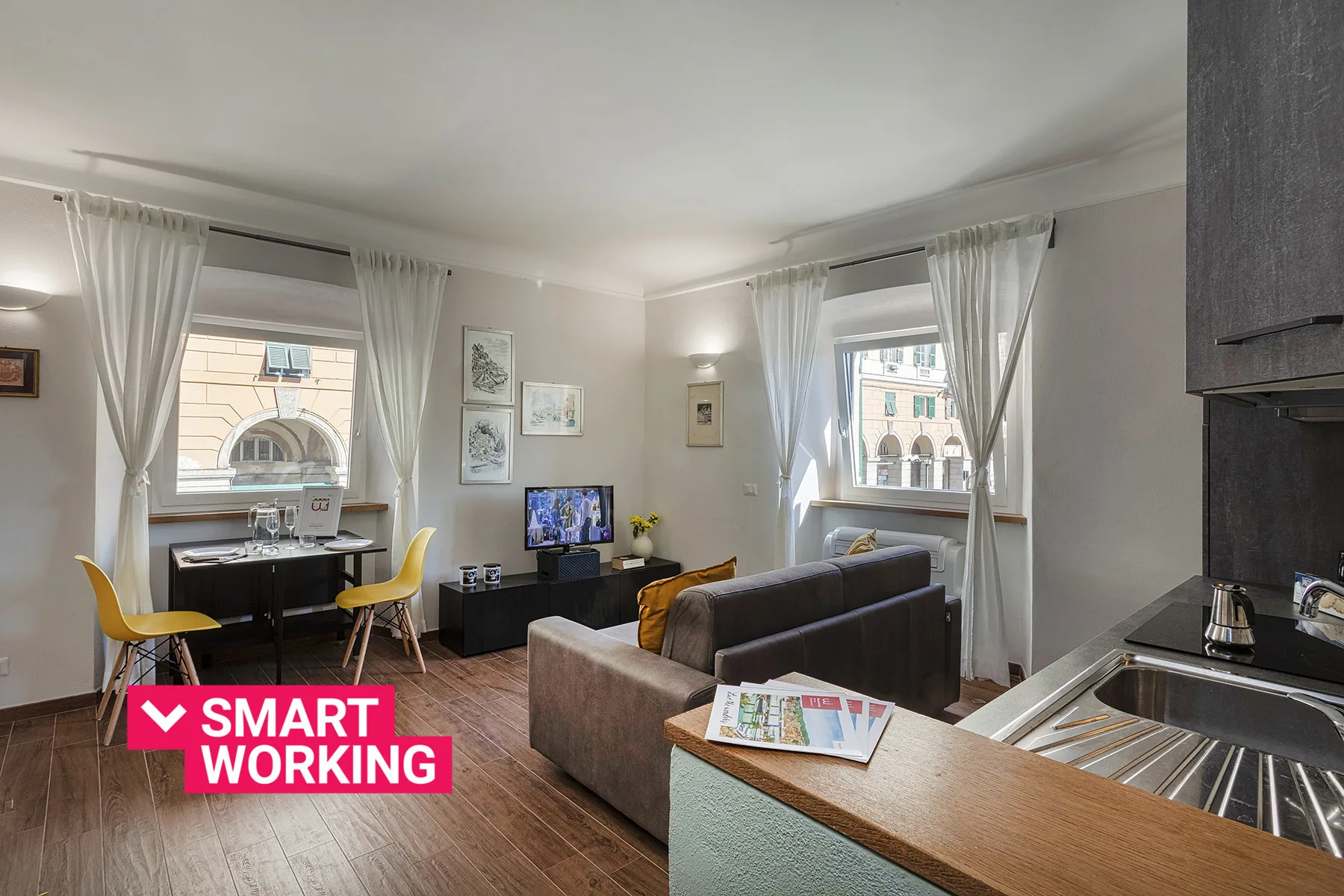 A bright living room with a dining table, seating, and a television.