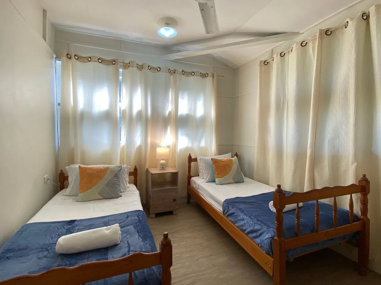 Un dormitorio con dos camas individuales junto a una mesita de noche.