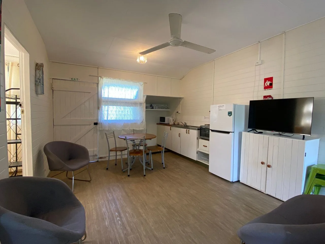 Una cocina compacta con comedor, asientos y un televisor.