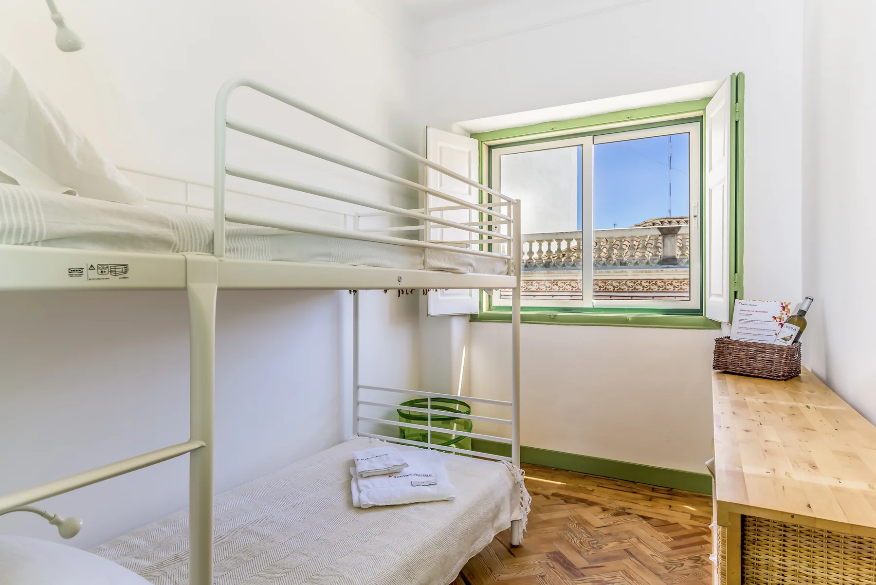 Zona de descanso con literas junto a una ventana y un escritorio de madera.