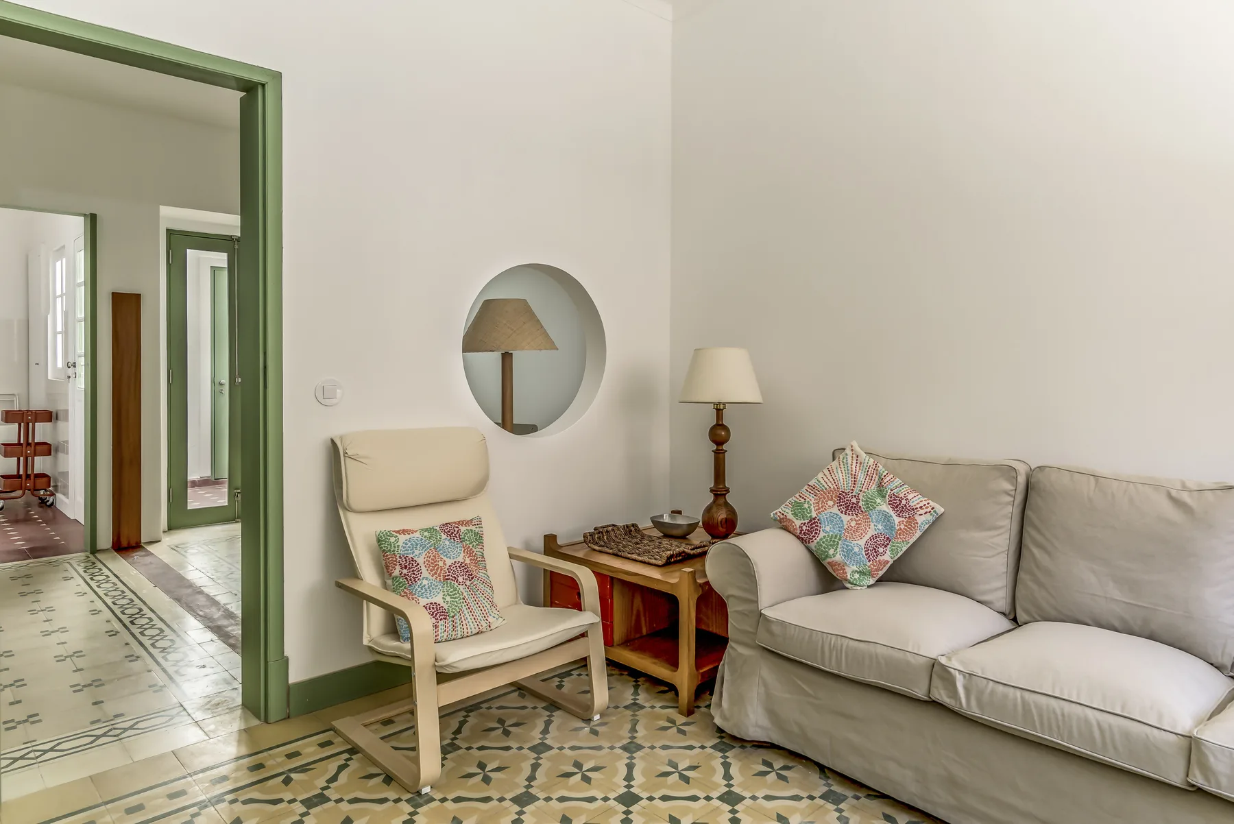 Una sala de estar con un sofá y un sillón junto a una mesa pequeña de madera.