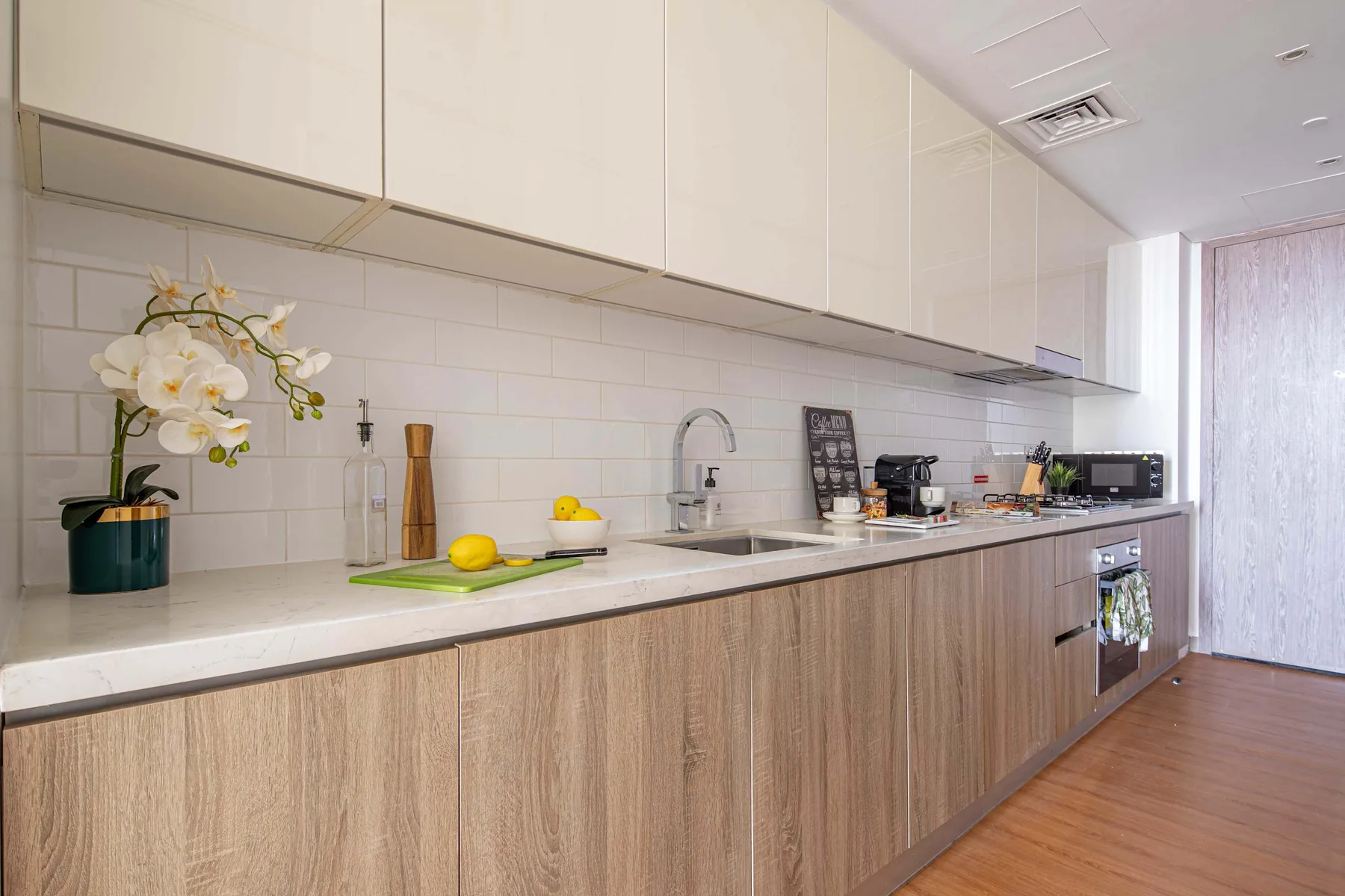 A modern kitchen with a long countertop, sink, and cabinets.