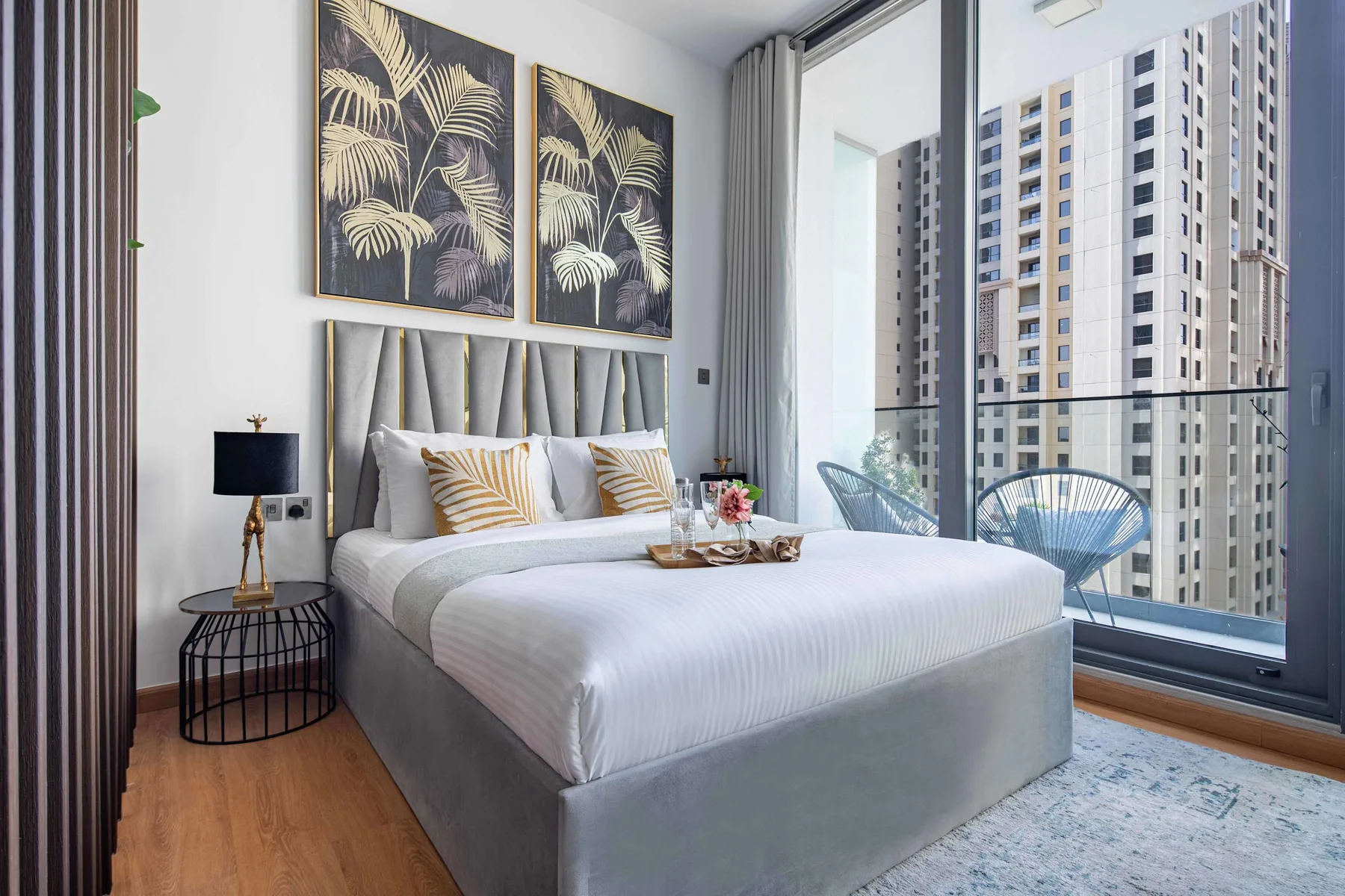 A bedroom with a bed beside a floor-to-ceiling window.
