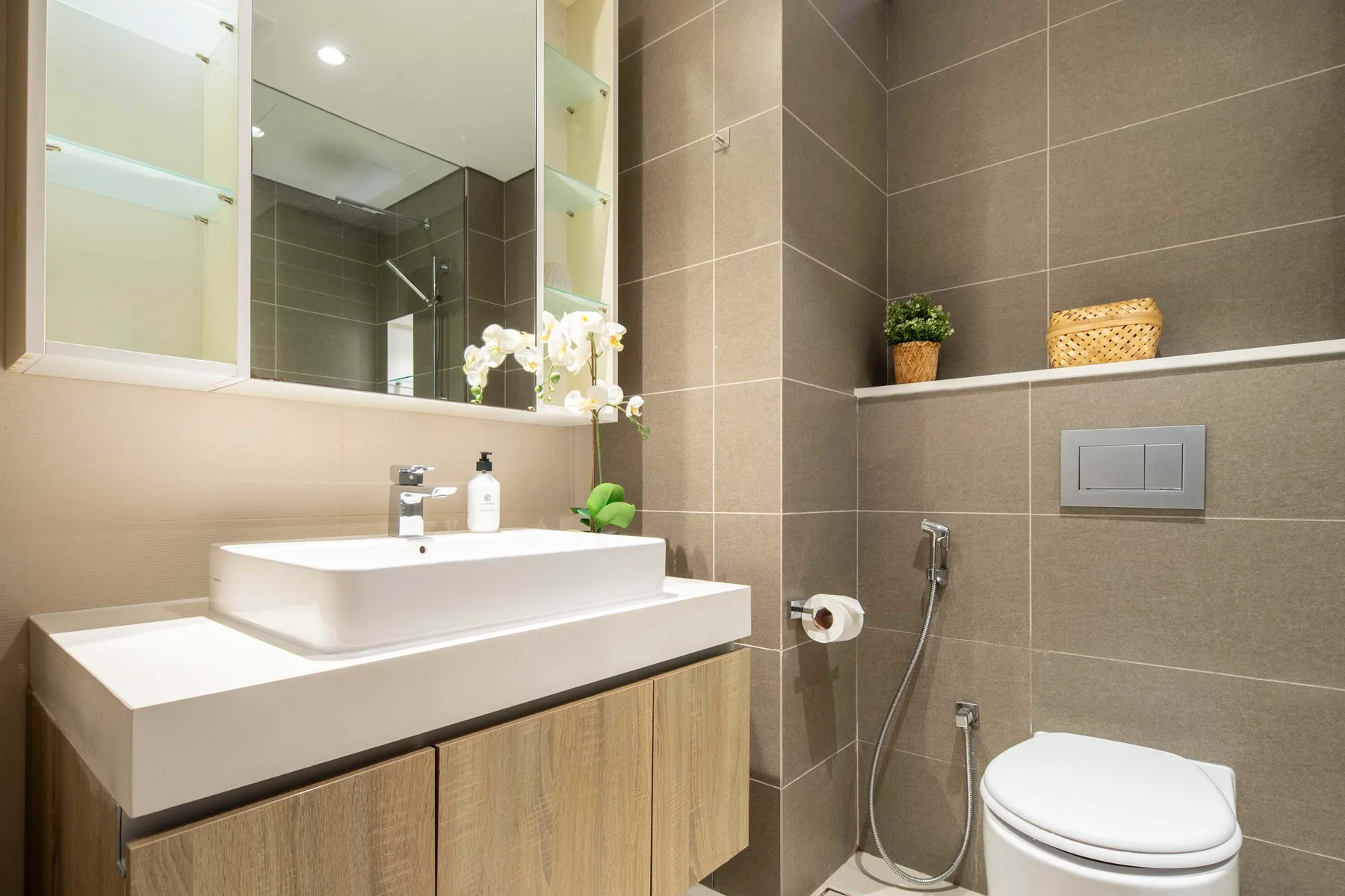 A modern bathroom with a wide sink and tiled walls.