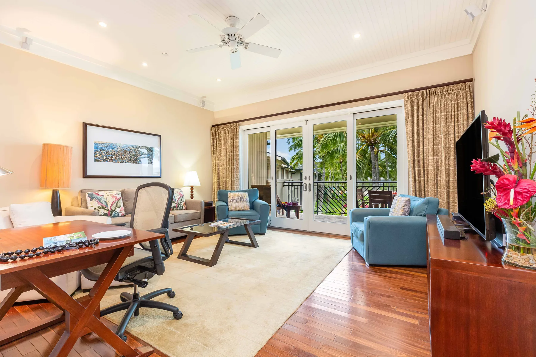 A bright living room with seating arranged around a glass coffee table.