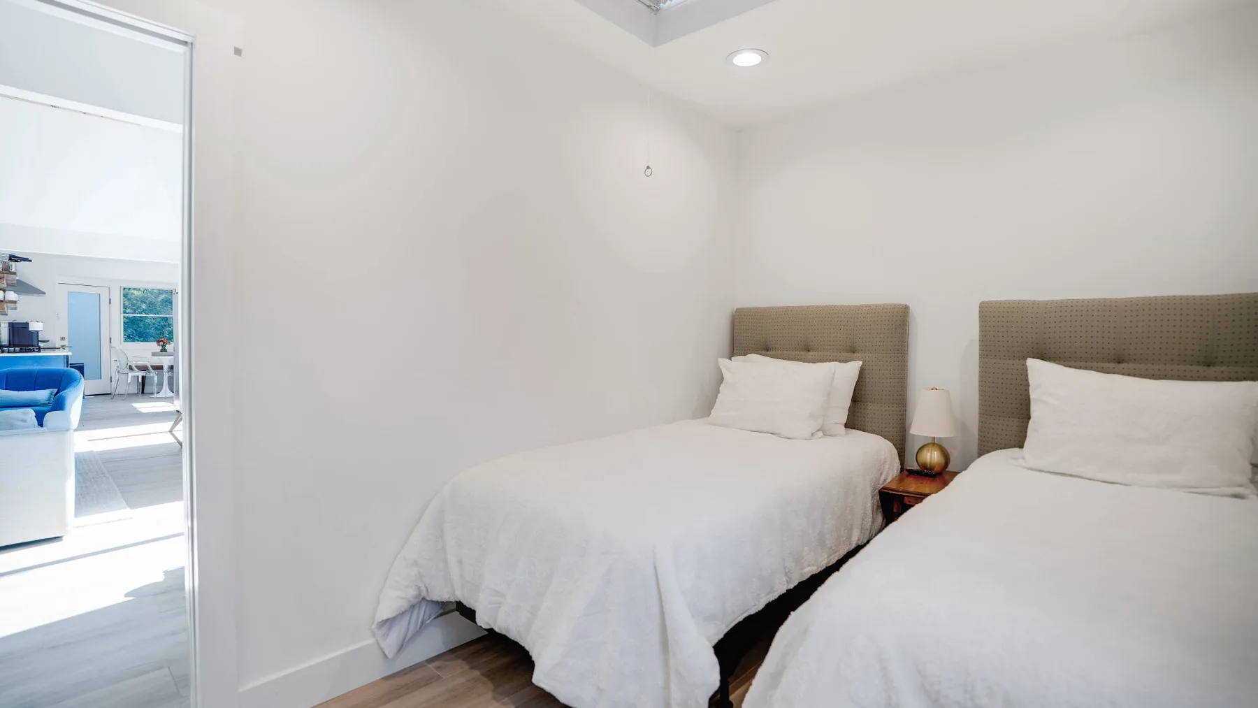 Un dormitorio con dos camas vestidas con ropa de cama blanca.