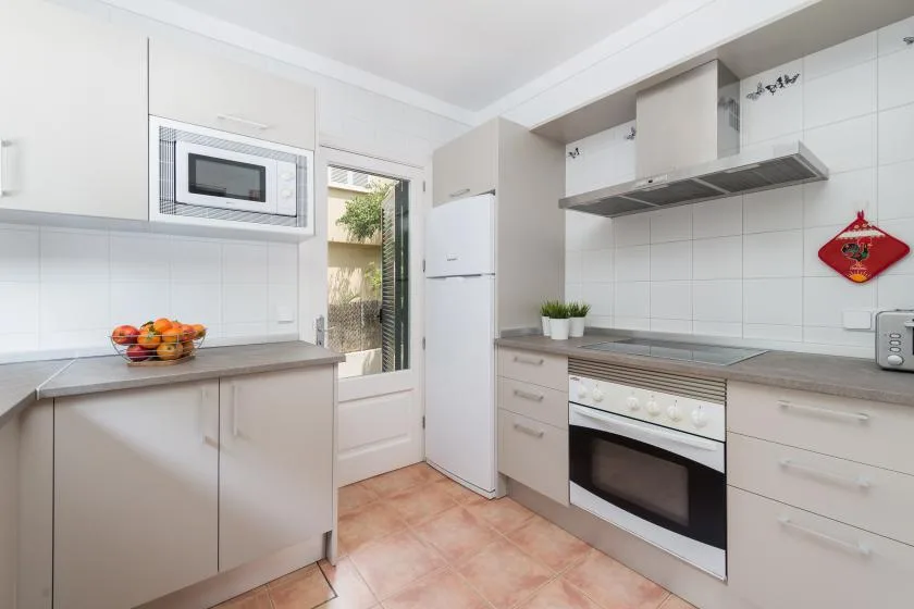 A bright kitchen with white cabinets, a countertop, and a built-in oven.