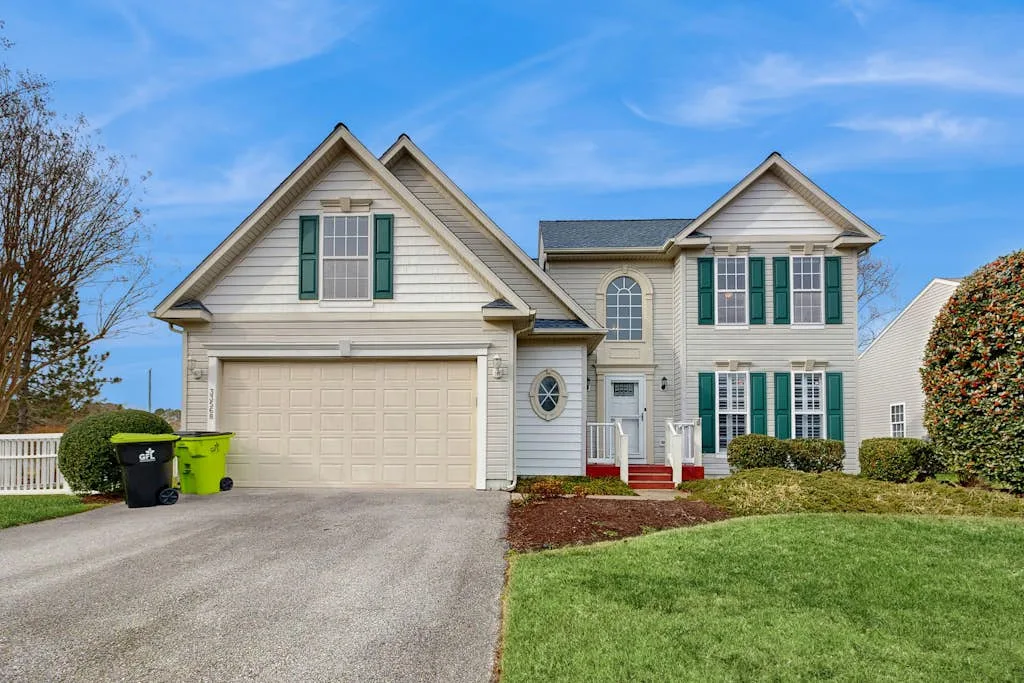 A two-story suburban house with a driveway, front lawn, and attached garage.